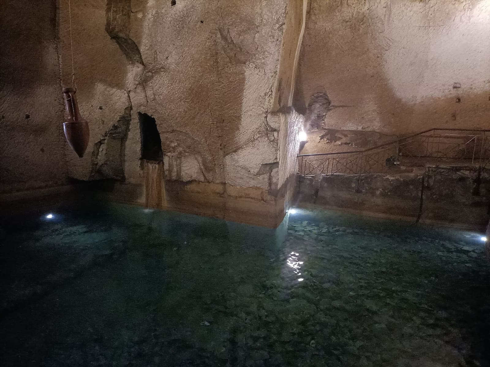 una cisterna scavata nel tufo con l'acqua sul fondo, nel percorso di Napoli Sotterranea