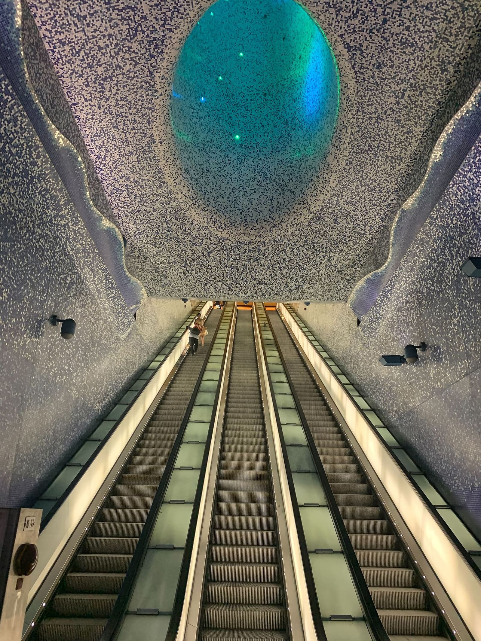 le scale mobili della stazione Toledo della metropolitana, sotto il cono di mosaico azzurro