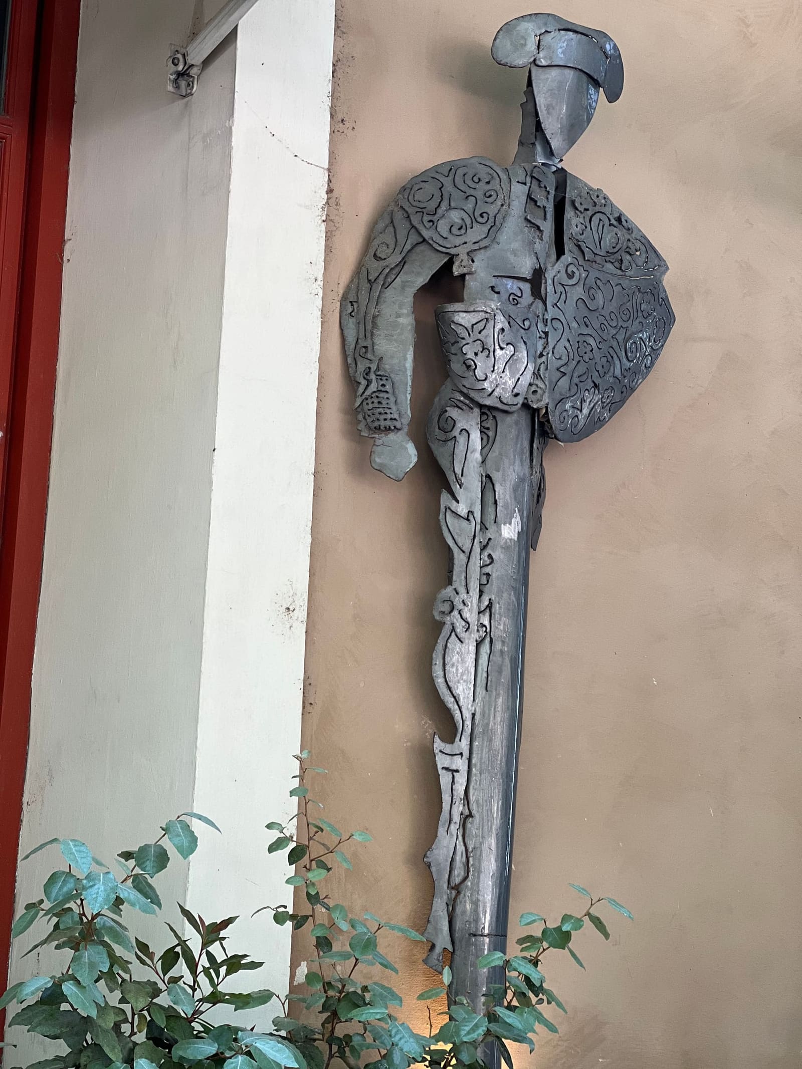 un torero di lamiera sagomata sul muro di una via del centro