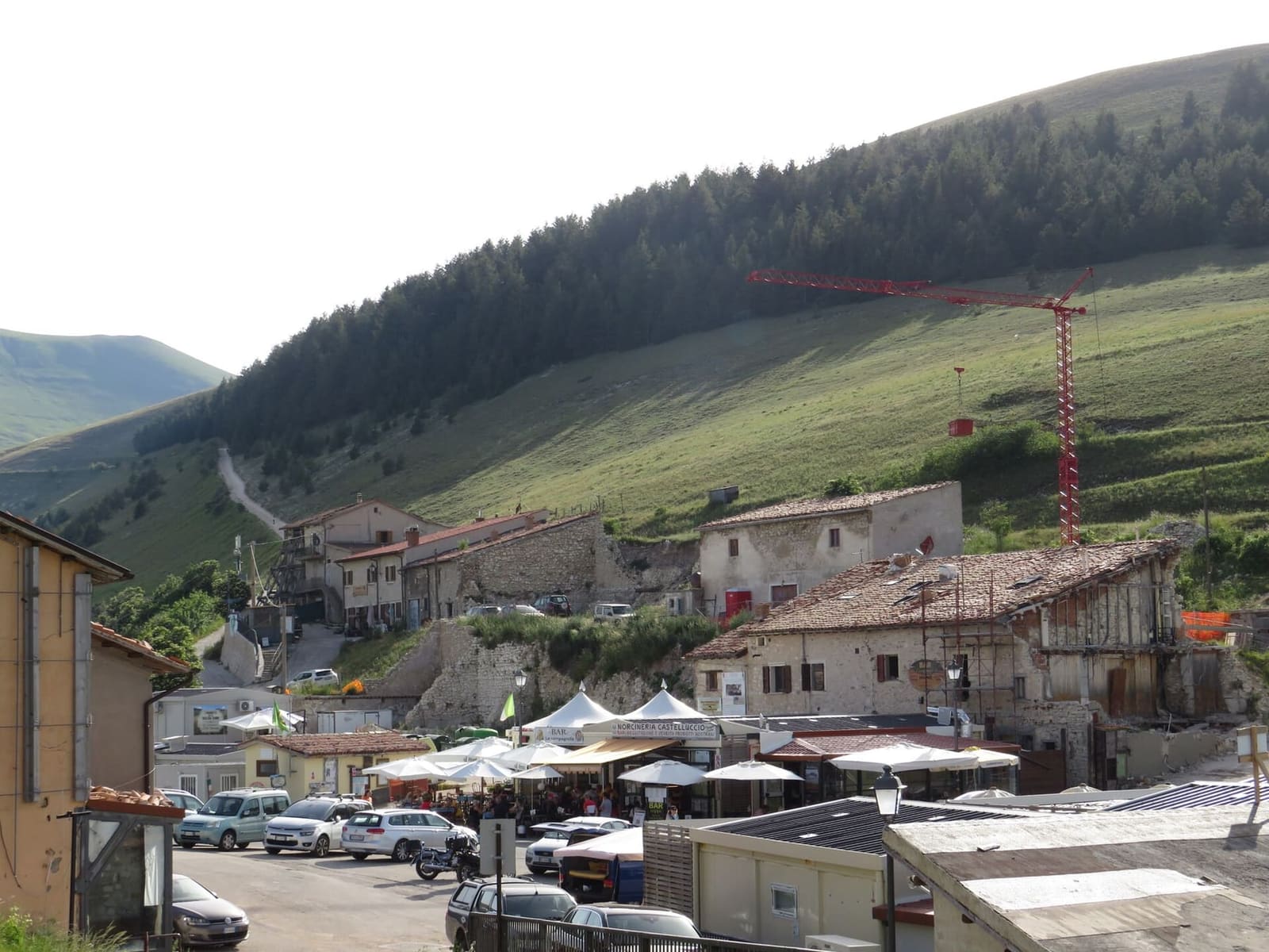 le case di Castelluccio, le bancarelle e la gru della ricostruzione, nel giugno 2022