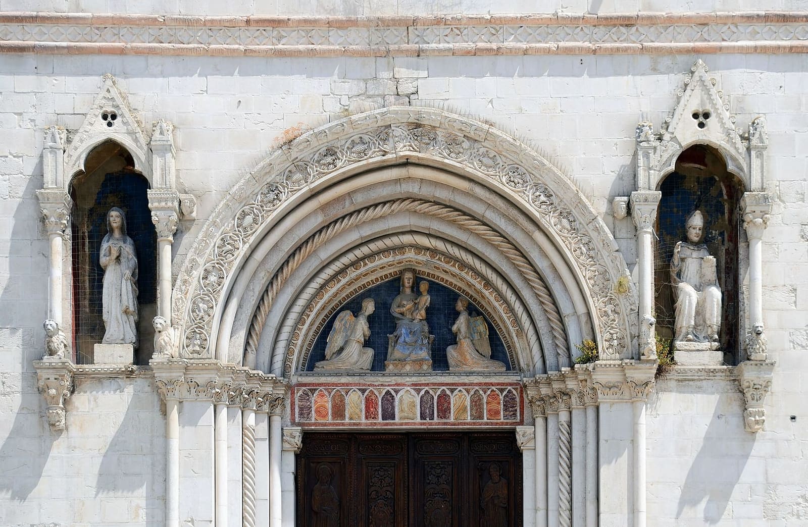 il portale gotico della basilica con le statue di Benedetto e Scolastica, nel 2015, prima del terremoto