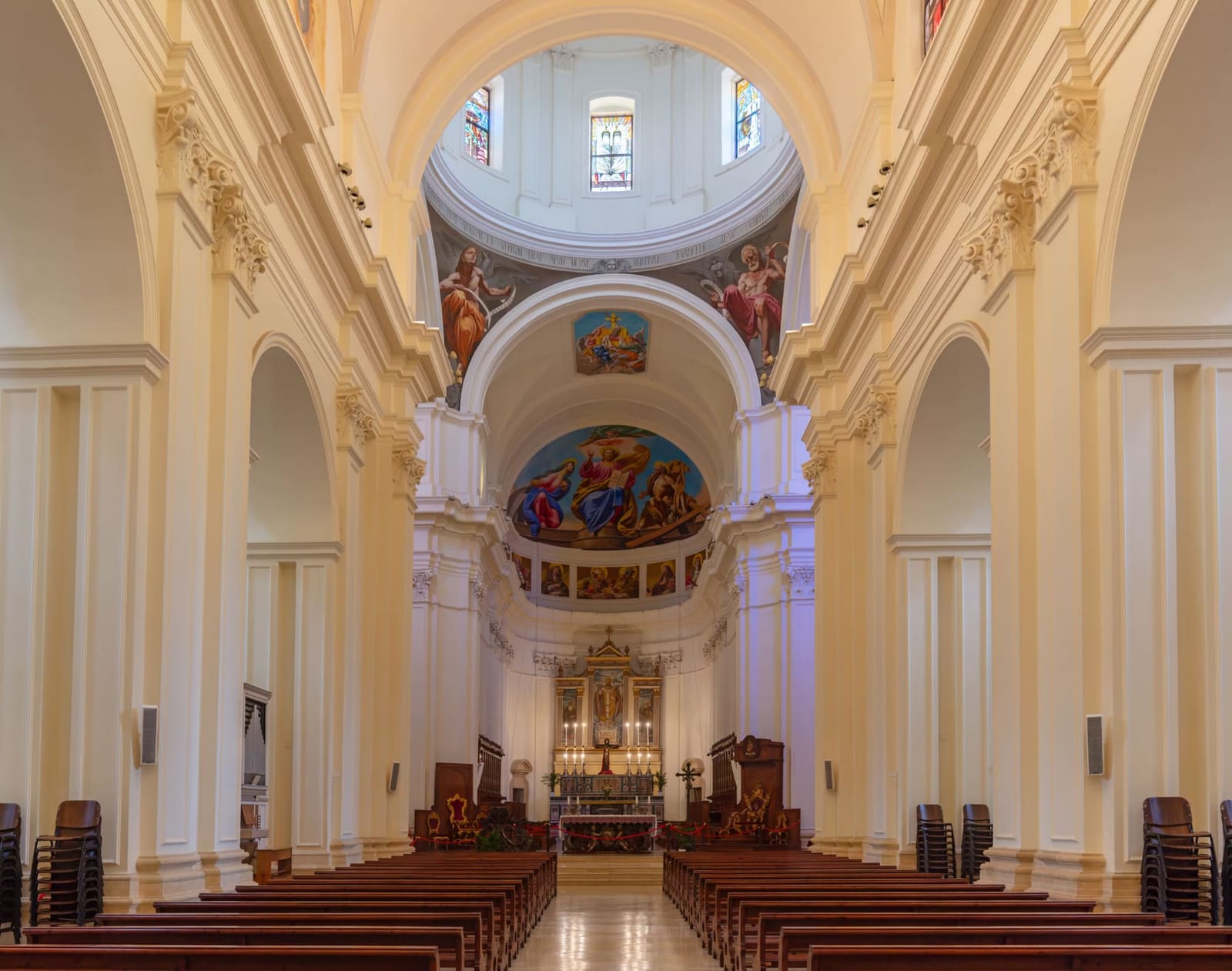 la navata della cattedrale ricostruita, bianca, con gli affreschi nuovi della cupola e dell'abside