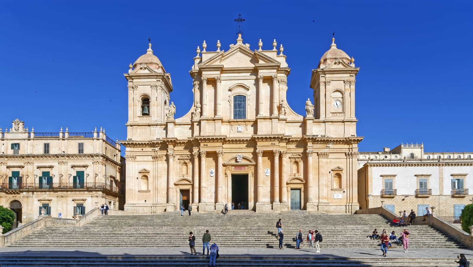 la cattedrale di San Nicolò in cima alla scalinata a quattro rampe, fra i palazzi della piazza