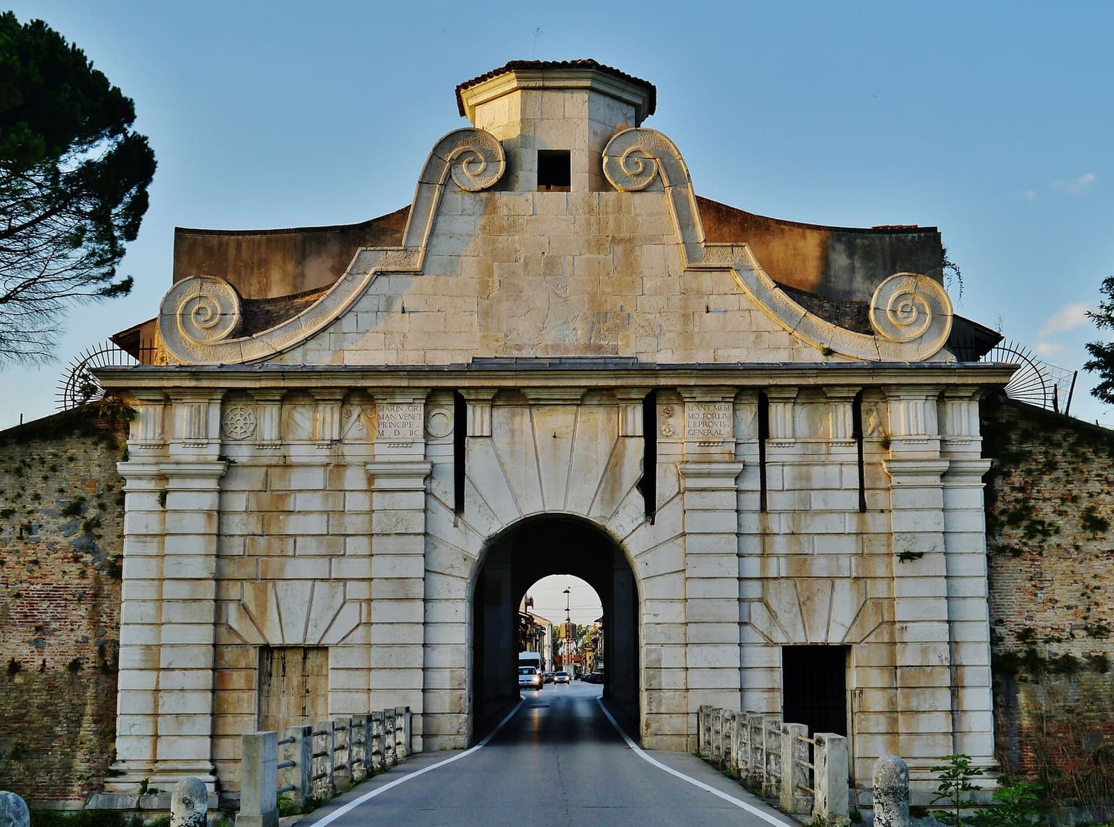 la Porta Aquileia avec son fronton à volutes, vue du pont sur le fossé