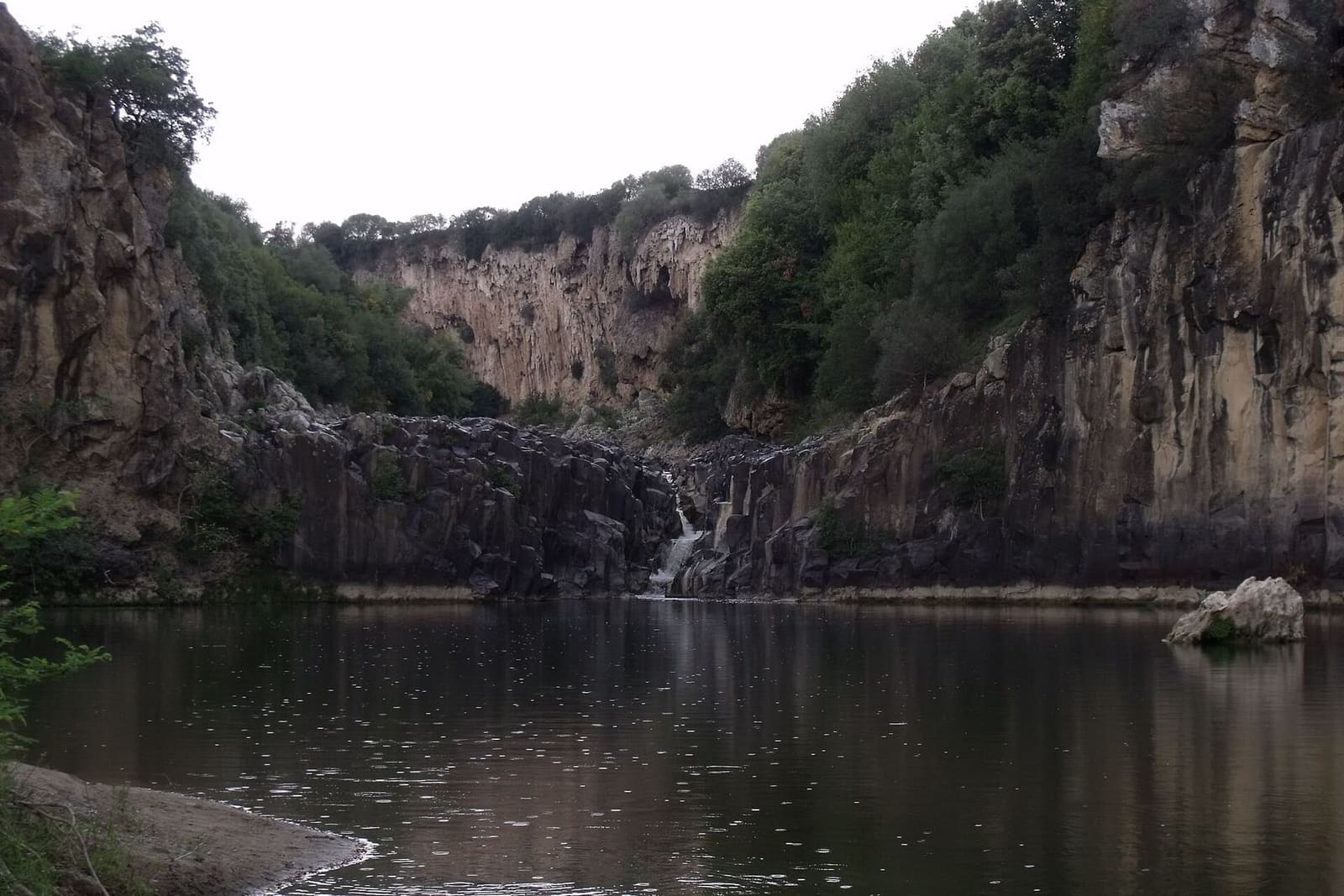 il laghetto del Pellicone, dove il Fiora si allarga sotto le pareti di roccia e una piccola cascata scende dal fondo
