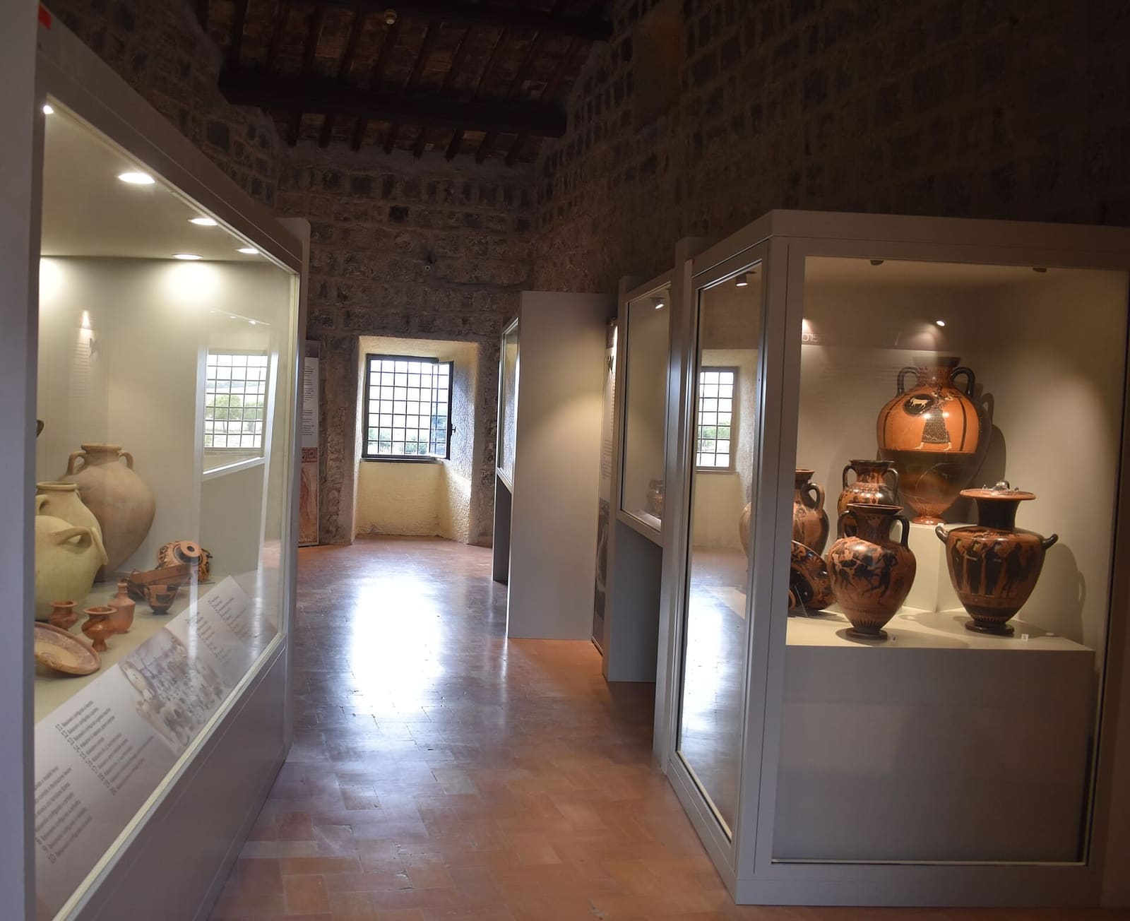 una sala del museo nazionale dentro il castello, con il soffitto a travi, le finestre con le grate e le vetrine dei vasi dipinti