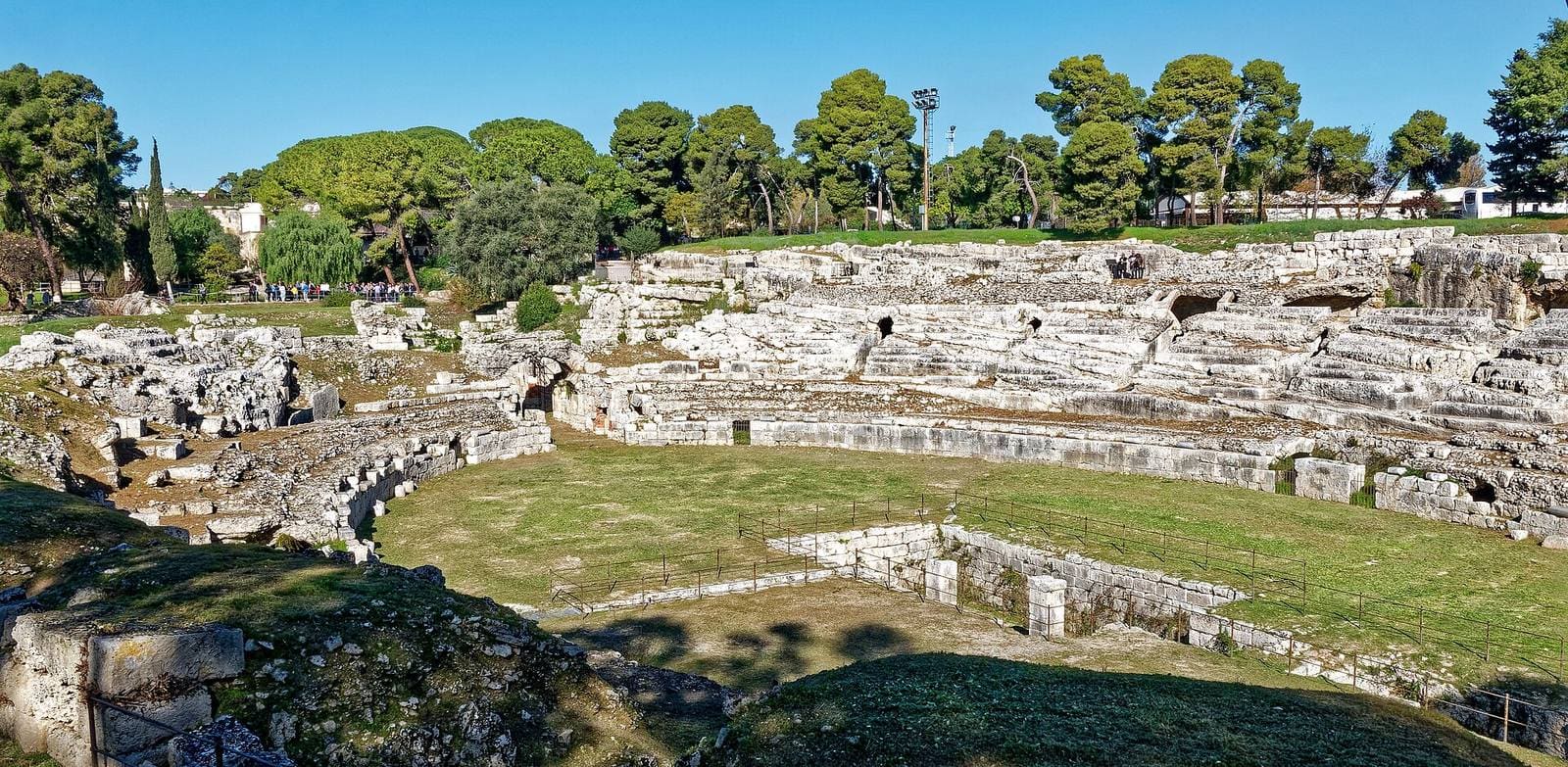 l'arena dell'anfiteatro romano e le gradinate scavate nella roccia, fra i pini