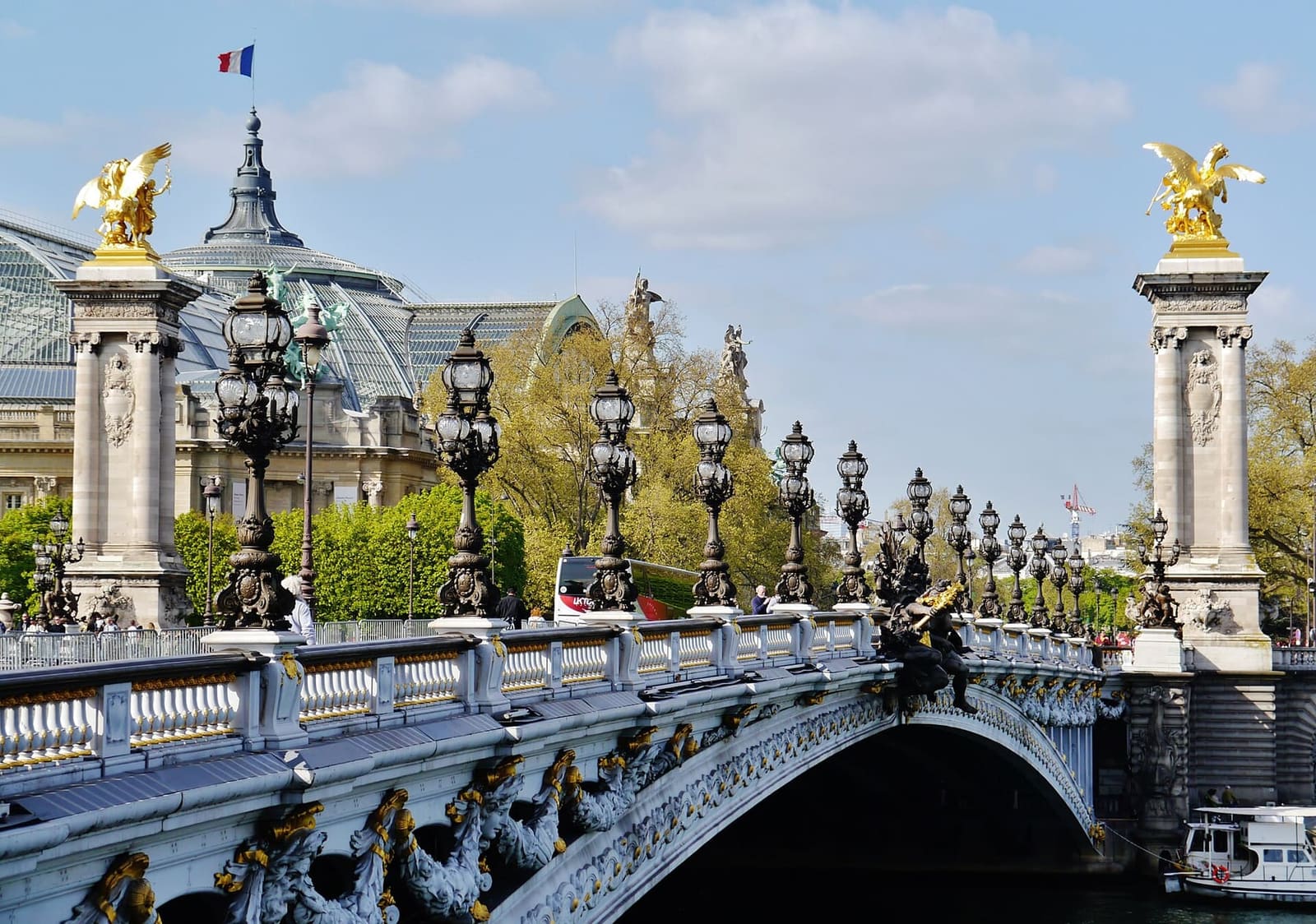 the Pont Alexandre-III with its lamps and gilded groups on the columns, and the dome of the Grand Palais behind