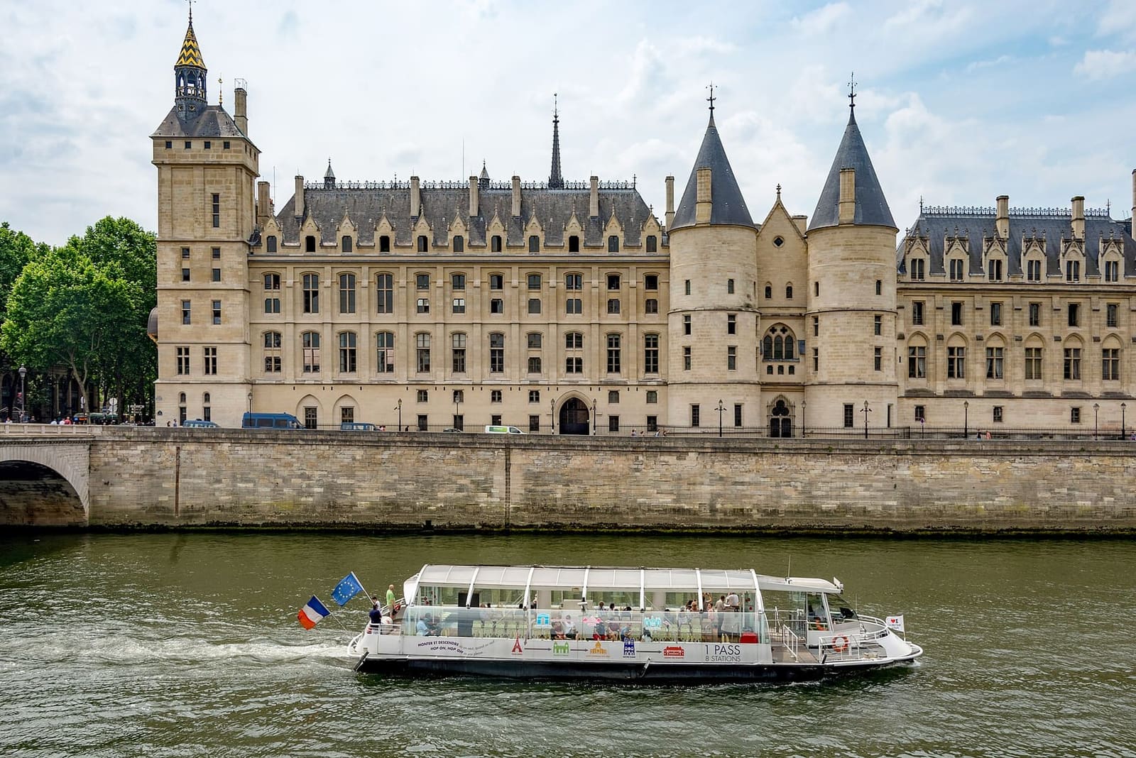 the Conciergerie on the Quai de l'Horloge, with the Batobus passing on the Seine