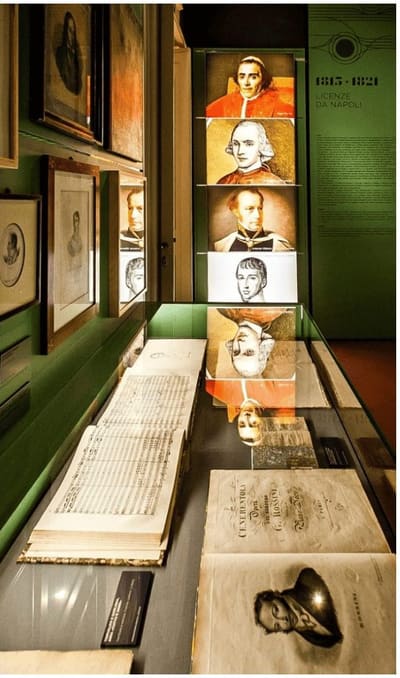 la sala del museo Rossini, con i ritratti retroilluminati e gli spartiti sotto vetro