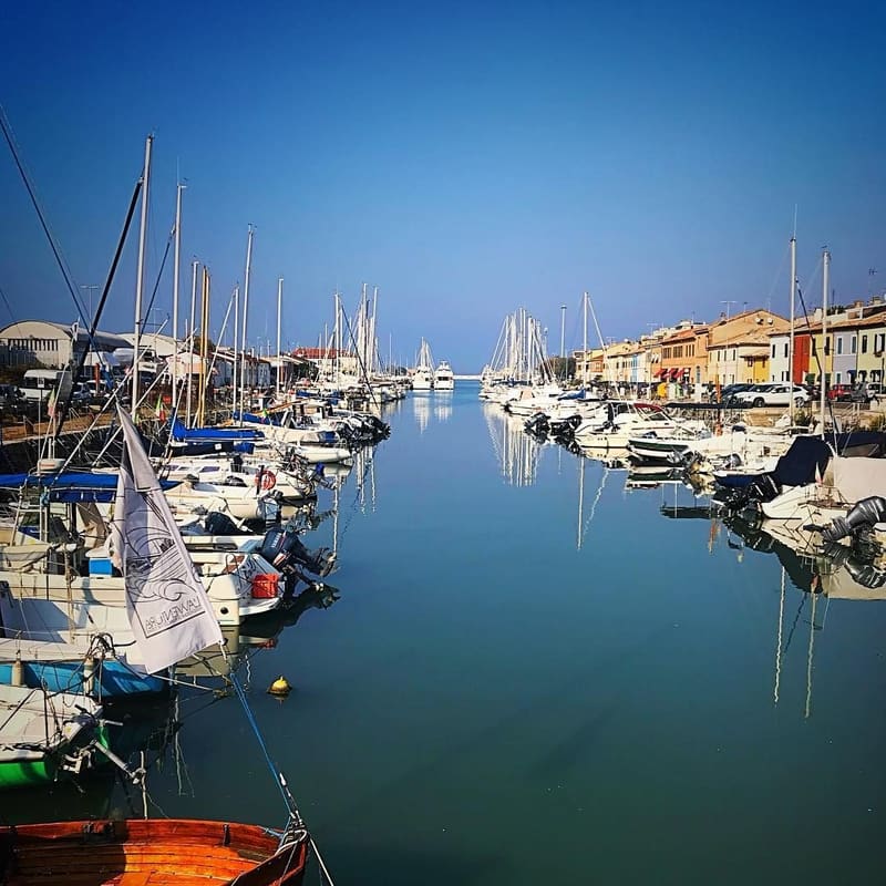 le barche a vela ormeggiate lungo il porto canale, con le case colorate sulla riva