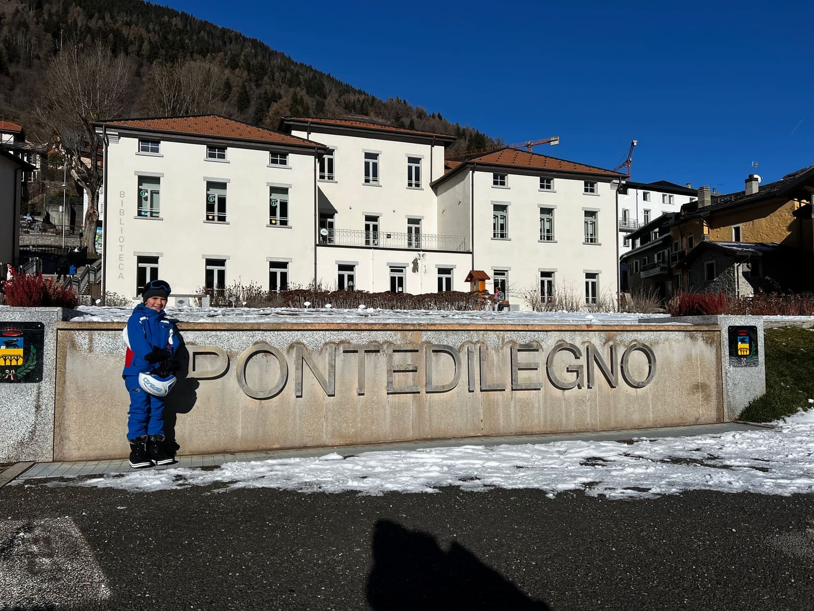 uno dei nostri davanti alla scritta di pietra PONTEDILEGNO, con il casco e la maschera in mano