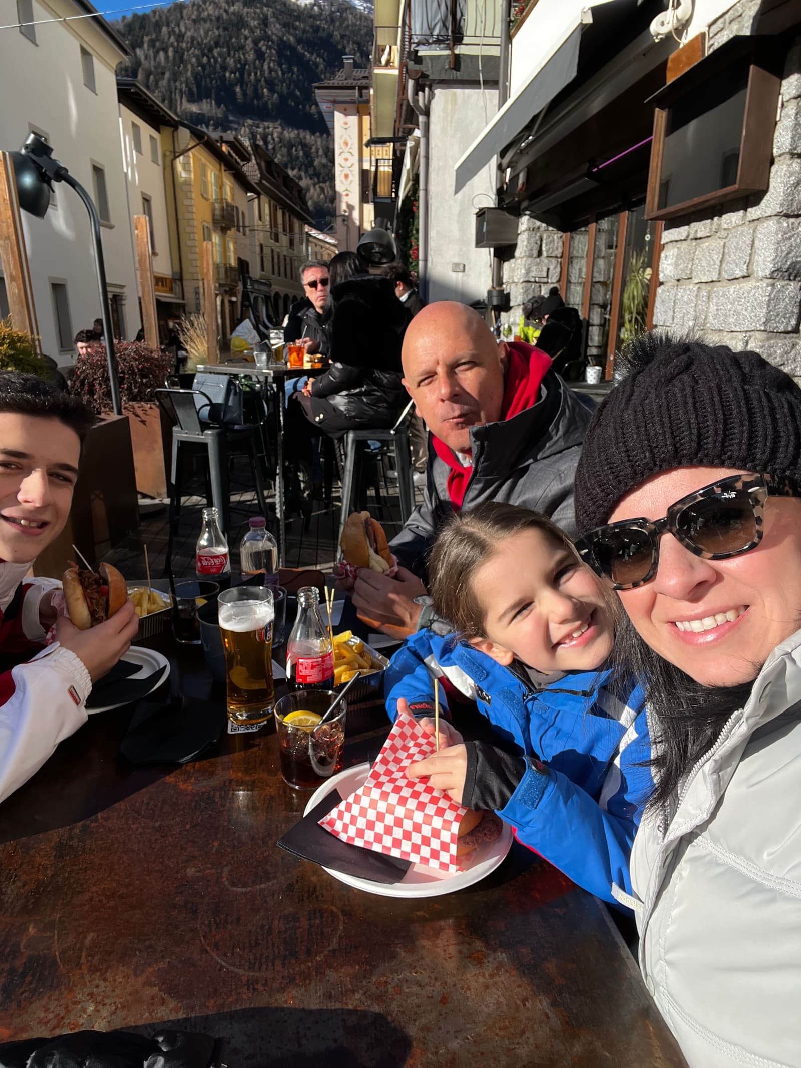 eccoci a tavola nel centro di Ponte di Legno, panini e patatine al sole di dicembre