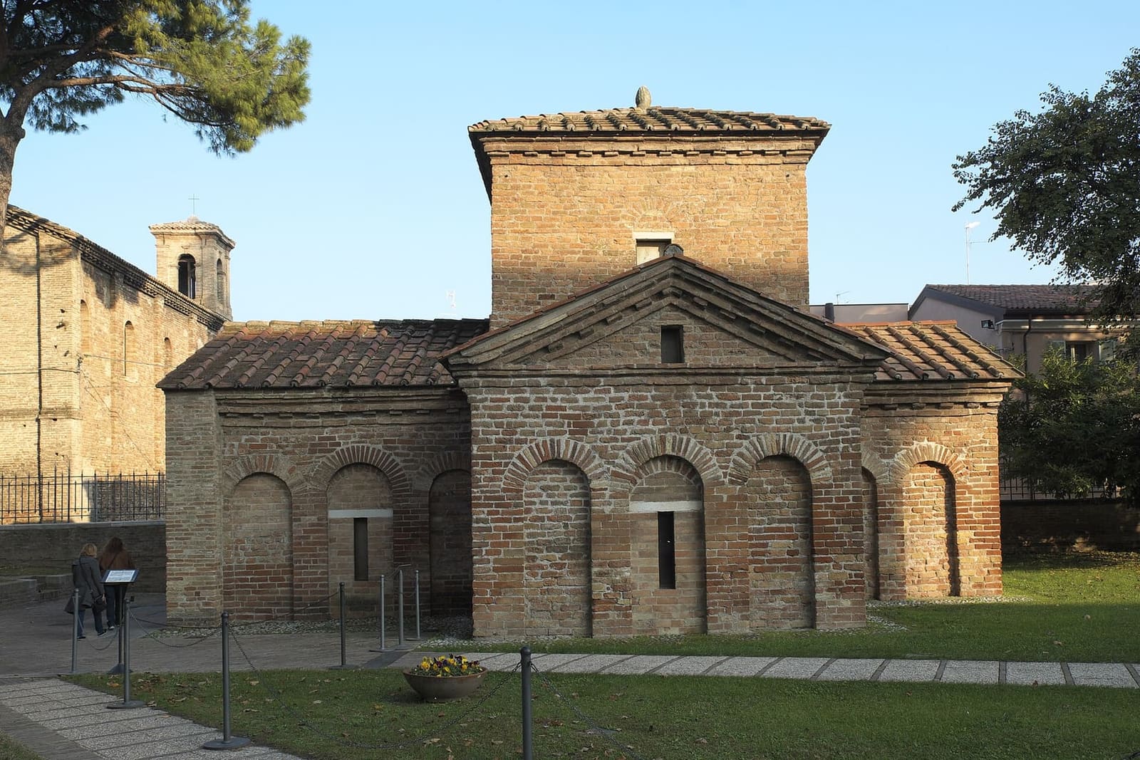 das Mausoleum der Galla Placidia, aus Ziegeln und mit kreuzförmigem Grundriss, auf der Wiese im Bezirk von San Vitale