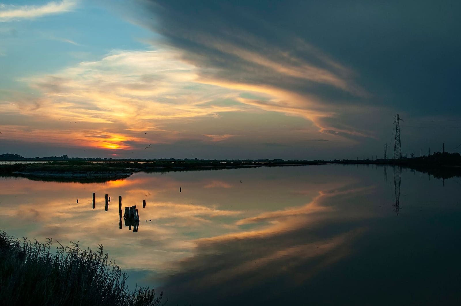 der Sonnenuntergang über den Becken der Saline von Cervia