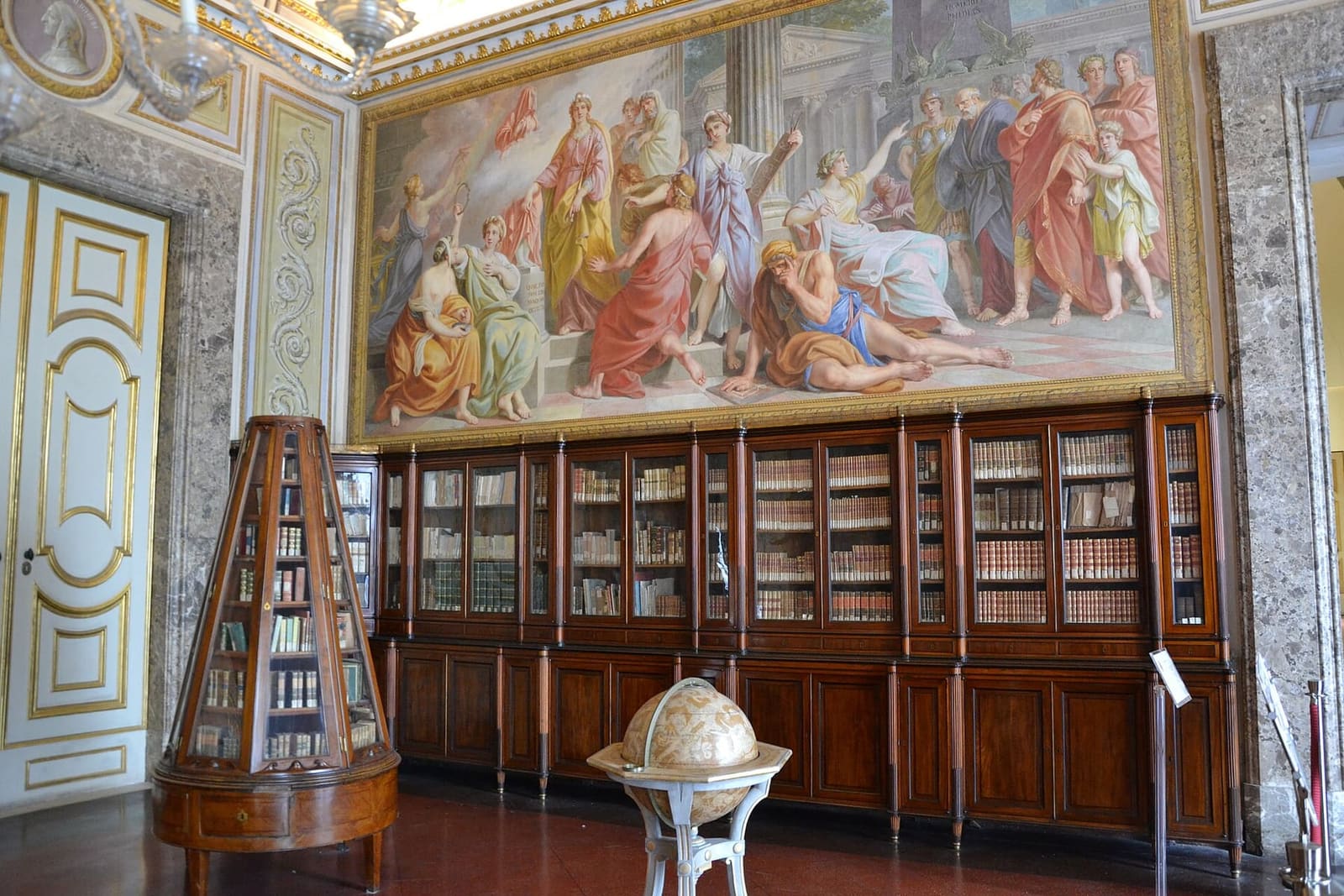 la Biblioteca Palatina con gli affreschi sopra gli scaffali e un globo