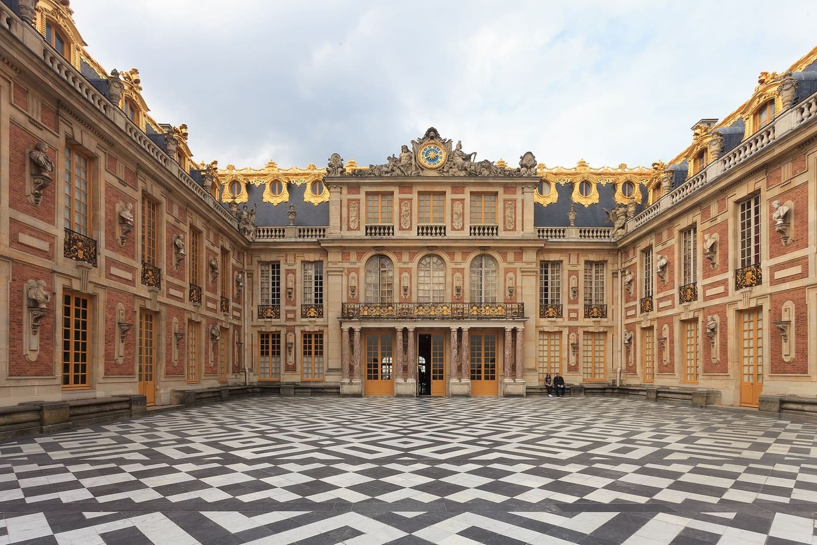 la cour de Marbre avec son dallage en damier et ses façades de brique et d'or