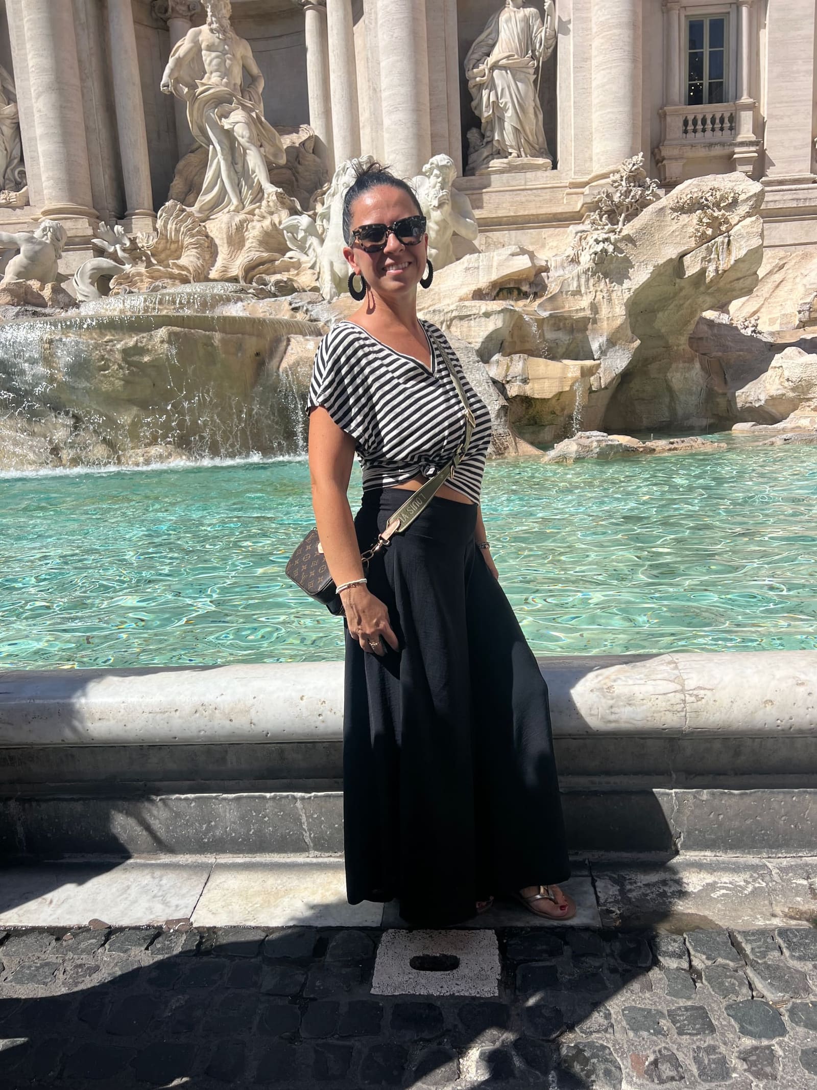 Marcella davanti alla fontana, sul bordo della vasca, alle tre del pomeriggio di un giorno di settembre
