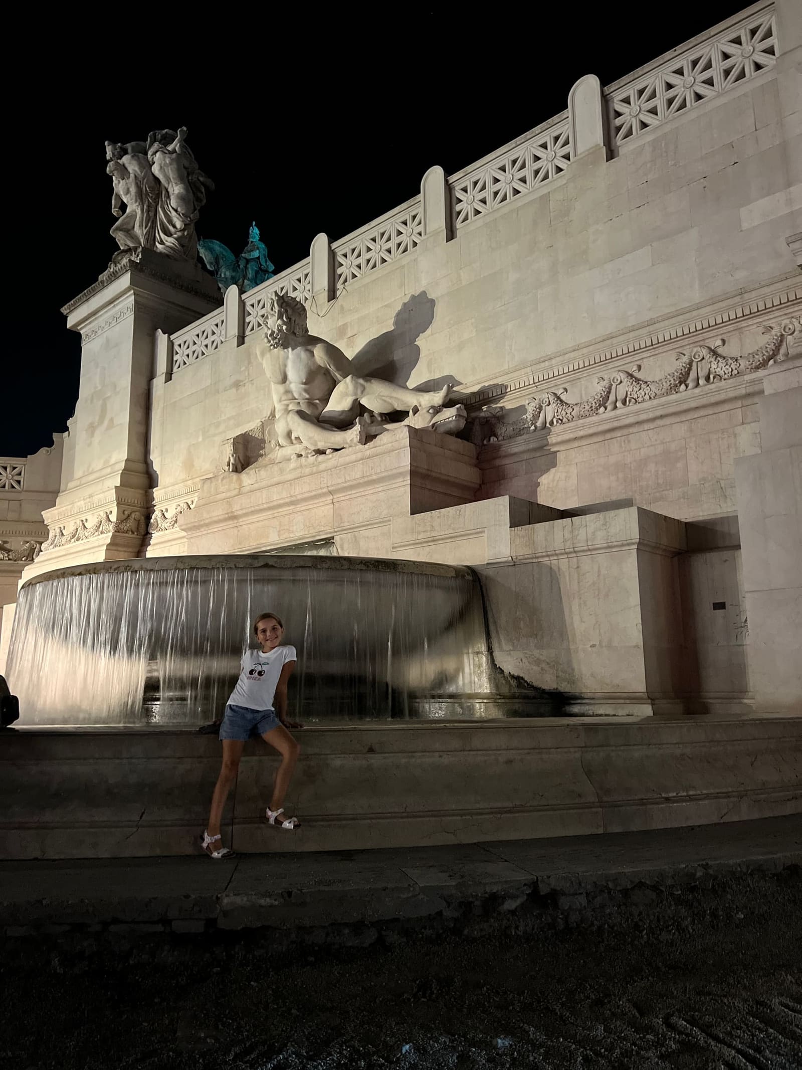 Letizia seduta sul bordo di una delle due fontane del Vittoriano, quella con il gruppo di marmo che rappresenta un mare