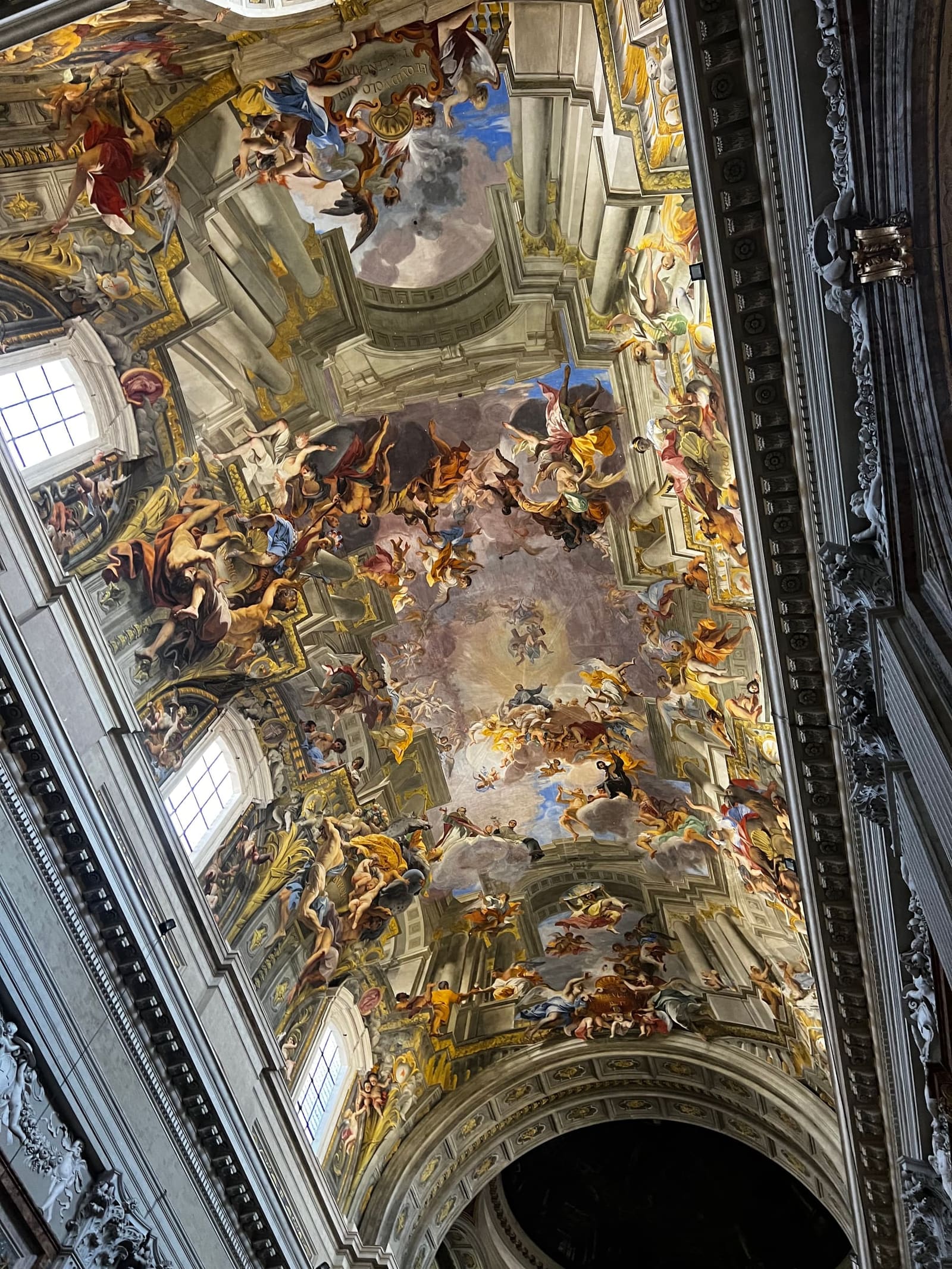 la volta presa per il lungo della navata: i corpi escono dalla cornice e fanno ombra sul soffitto vero