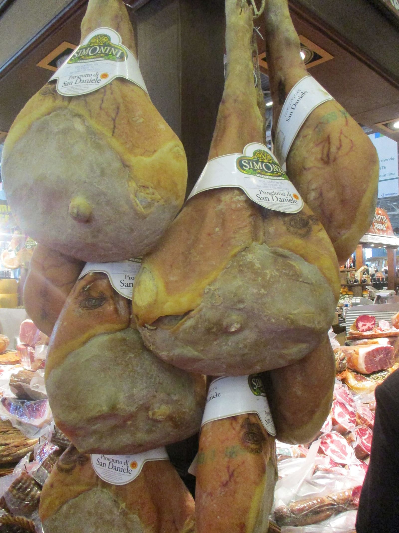 prosciutti di San Daniele appesi, con il collarino del marchio sulla cotenna