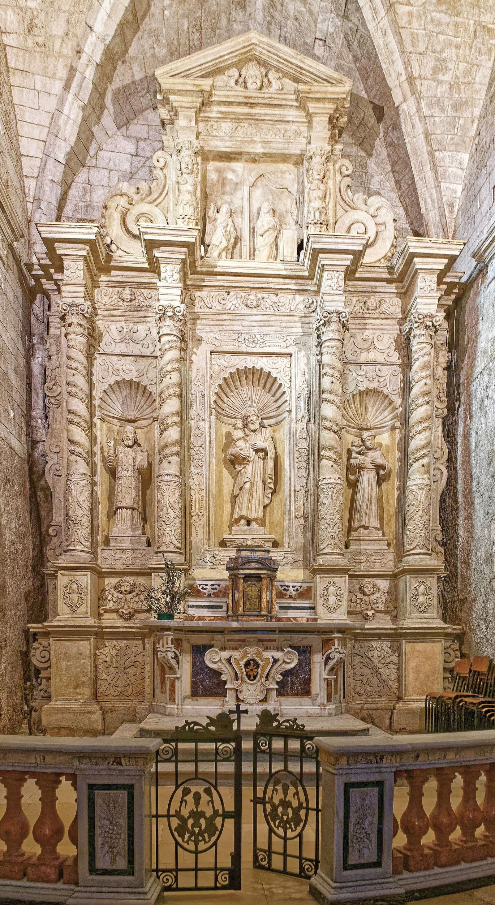 un autel baroque avec les statues des saints, dans la grotte