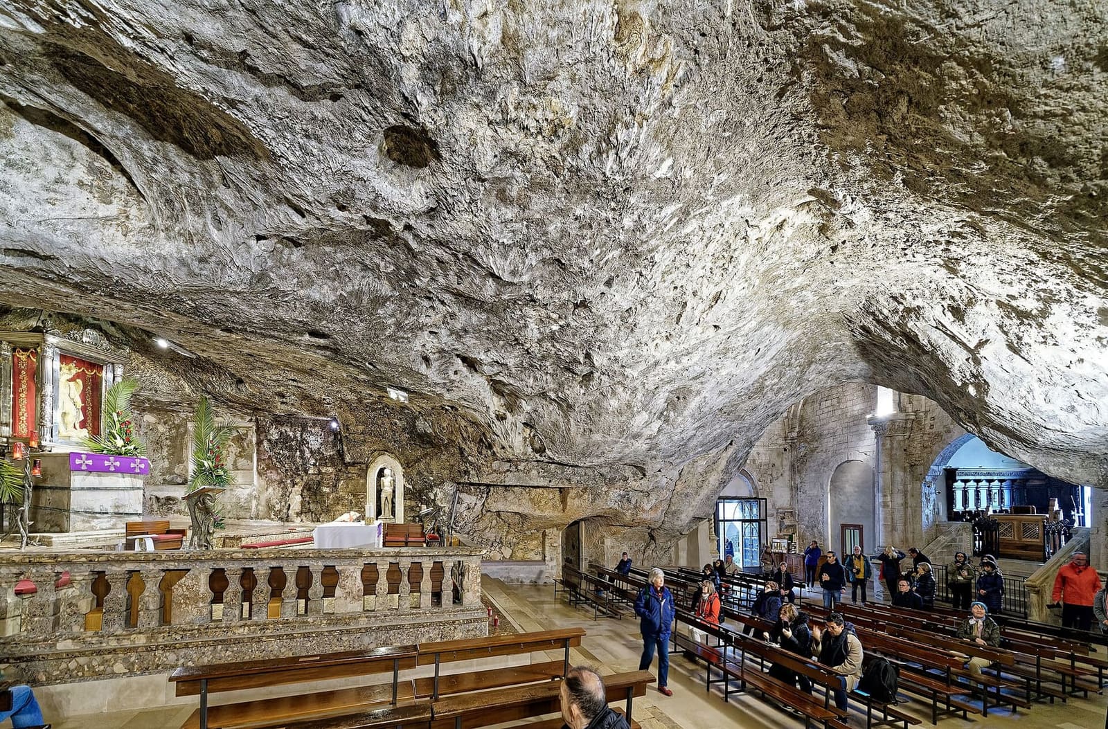 la grotta dell'Arcangelo, con la volta di roccia sopra l'altare e i banchi