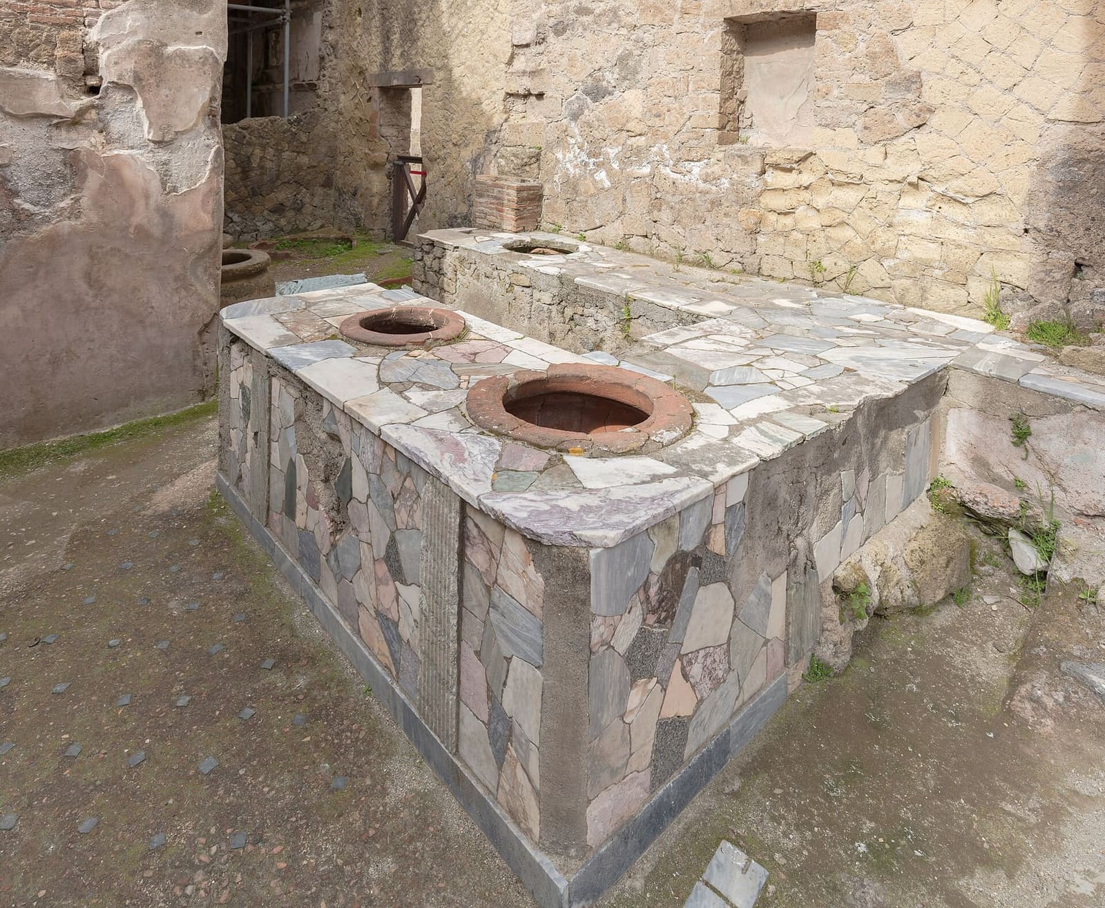il bancone di marmi colorati di un thermopolium, con i vasi incassati