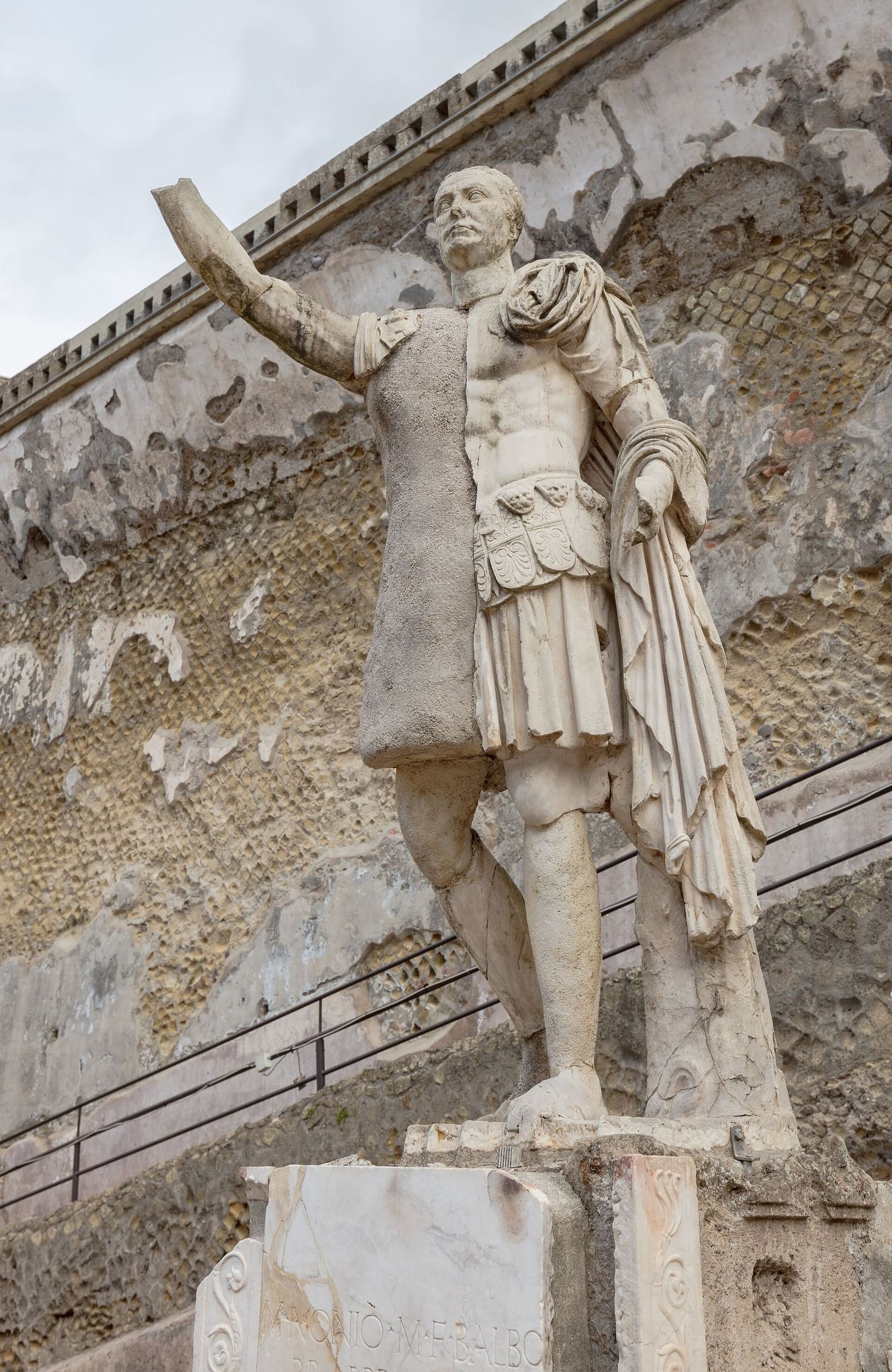 la statua di Marco Nonio Balbo con il braccio alzato, contro la parete di tufo