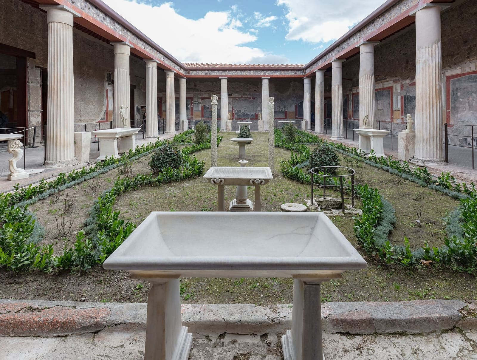 il peristilio della Casa dei Vettii, con il giardino, le vasche di marmo e le colonne, a marzo