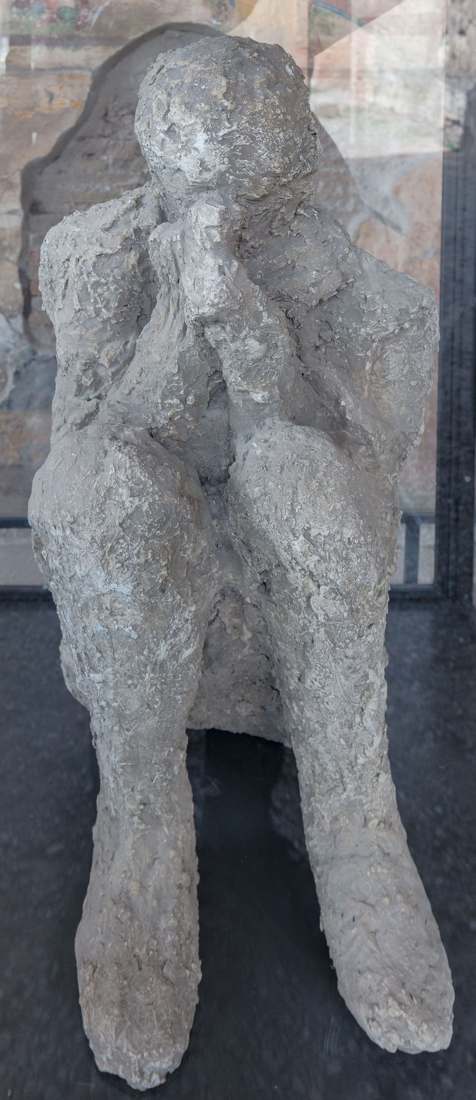 il calco di un uomo seduto con le mani sul viso, esposto nel Macellum nel marzo 2023
