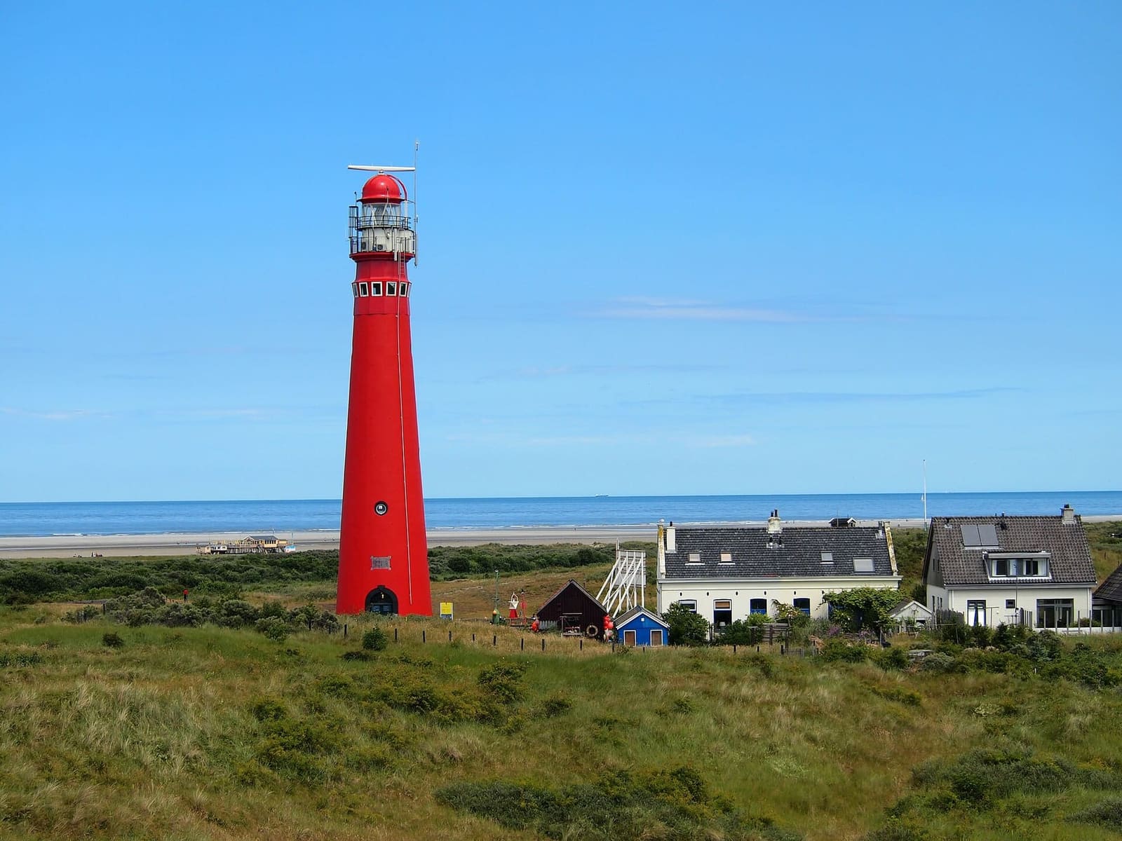 il faro rosso, la Noordertoren, fra le dune, con il mare sullo sfondo