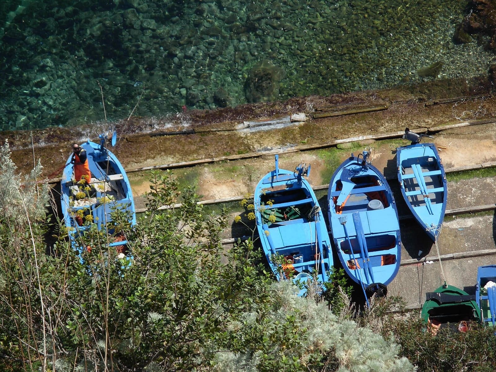 le barche azzurre dei pescatori tirate a secco, viste dall'alto