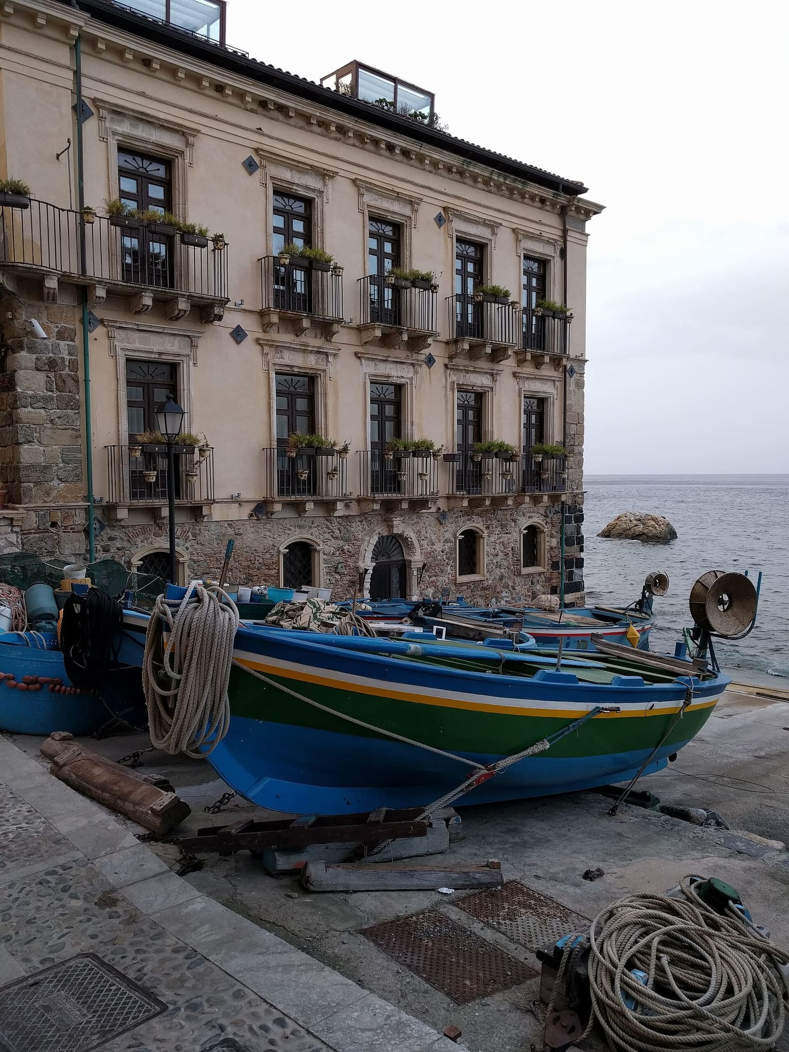 un palazzo di Chianalea sul mare e una barca a secco con le funi