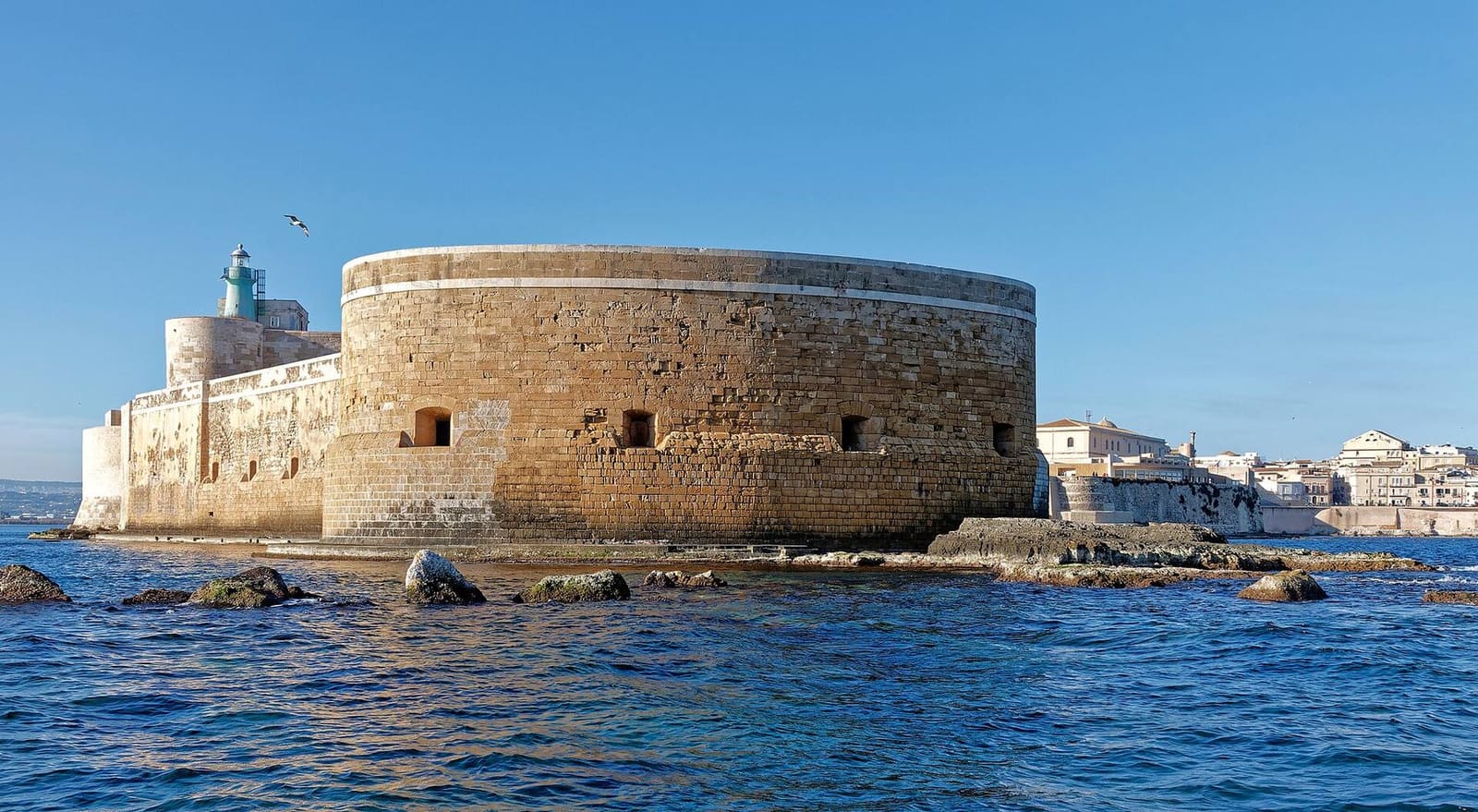 das Castello Maniace vom Meer aus gesehen, mit der runden Bastion und dem grünen Leuchtfeuer an der Spitze von Ortigia