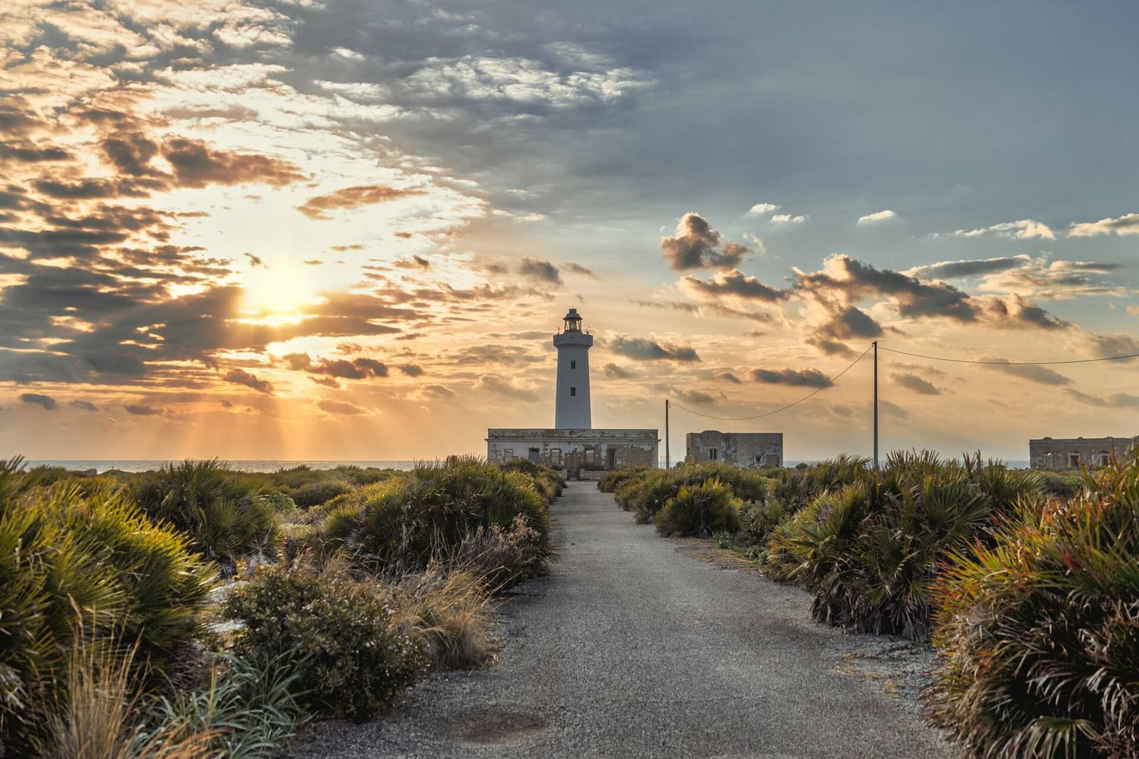 der Leuchtturm von Capo Murro di Porco im Morgengrauen, am Ende der Straße durch die Macchia des Plemmirio