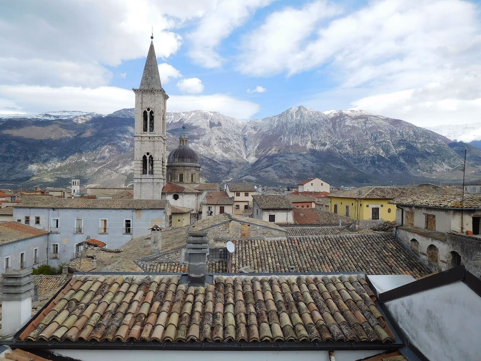 die Dächer von Sulmona und der Glockenturm der Annunziata, mit den verschneiten Bergen dahinter