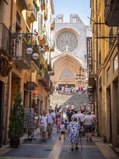 il rosone e il portale della cattedrale in fondo alla via stretta, con la scalinata piena di visitatori