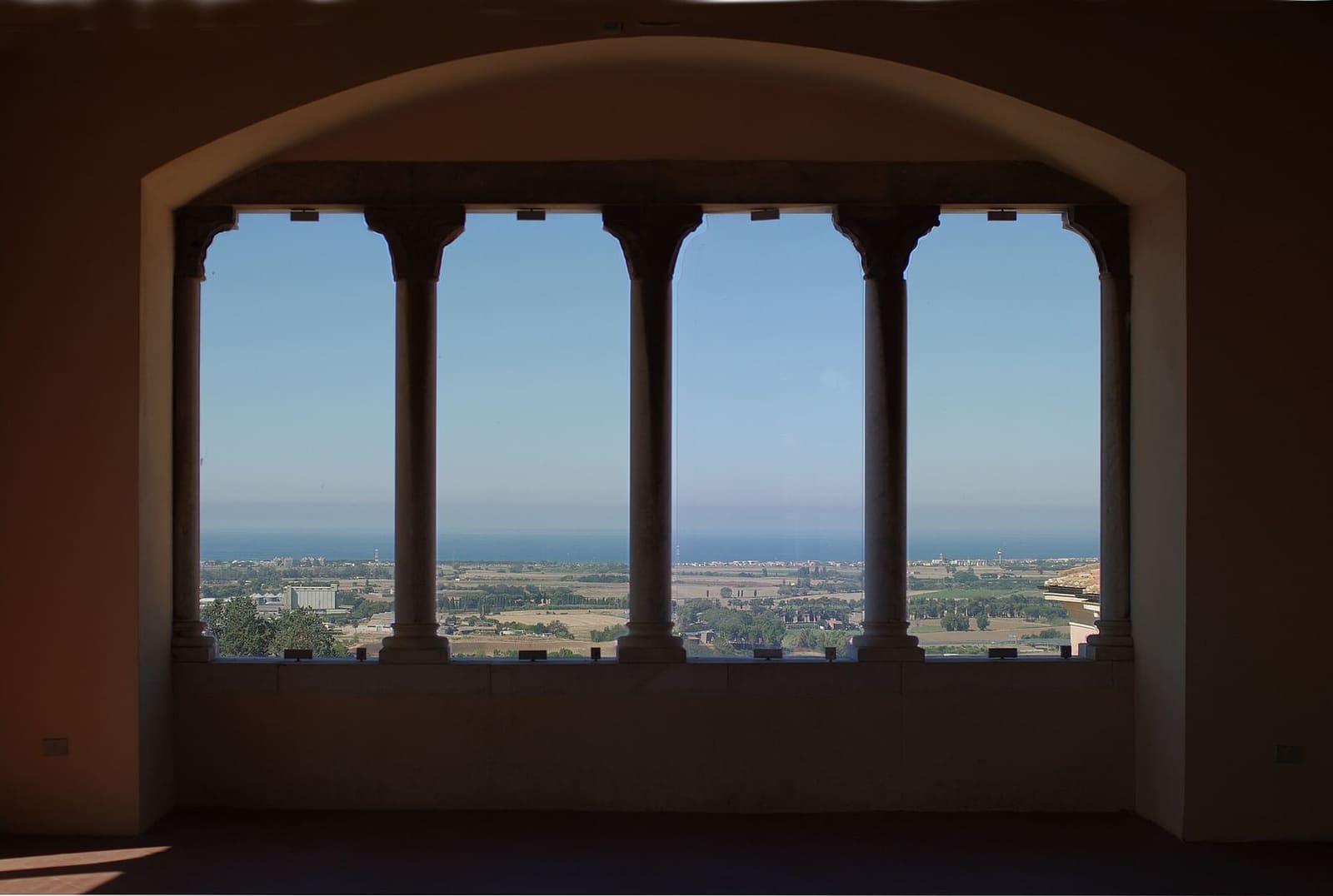 dalla quadrifora della loggia di palazzo Vitelleschi si vede la piana della Maremma fino al mare, verso il Lido di Tarquinia