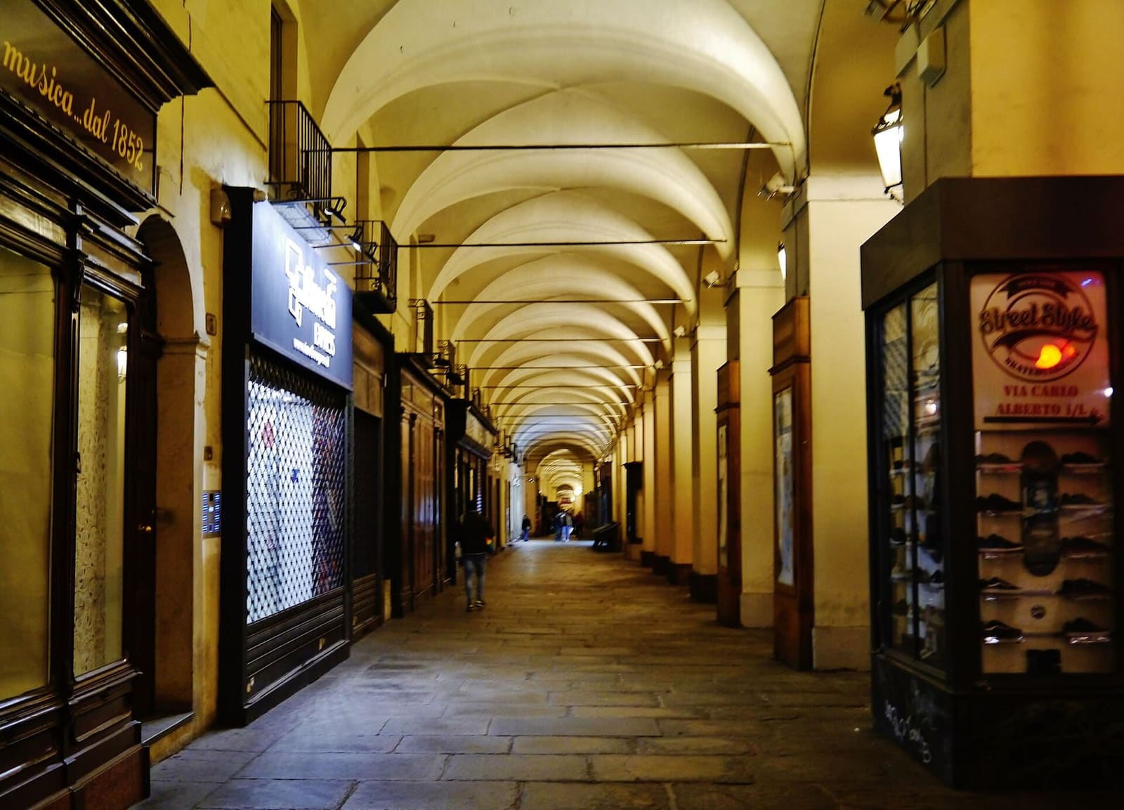 i portici di via Po la sera, con le volte illuminate che corrono dritte verso piazza Castello
