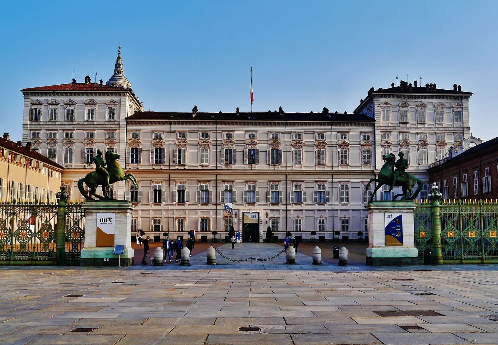 la facciata del Palazzo Reale in fondo a piazzetta Reale, dietro la cancellata con le statue dei Dioscuri