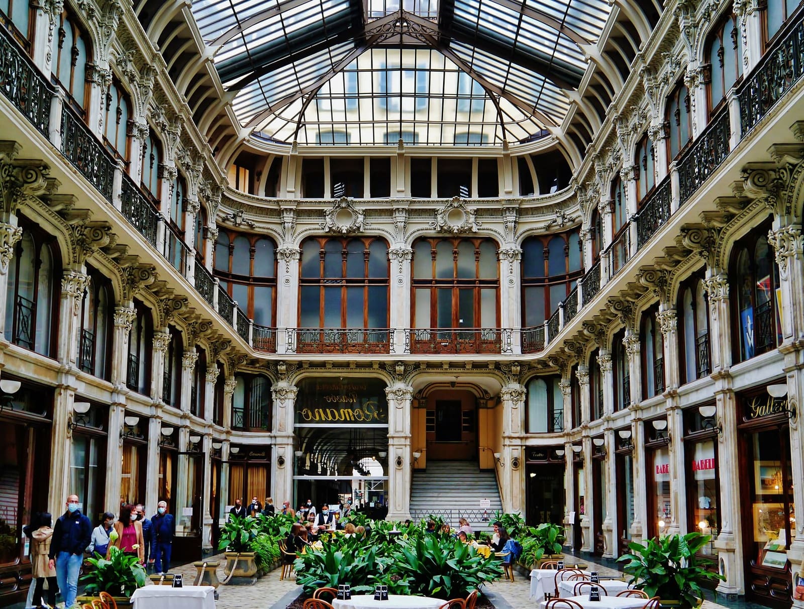 la Galleria Subalpina, sotto la volta di ferro e vetro, con le piante al centro e le balaustre del piano di sopra