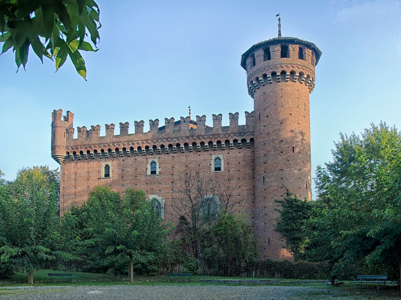 la Rocca del Borgo Medievale, con la torre tonda e i merli, fra gli alberi del parco