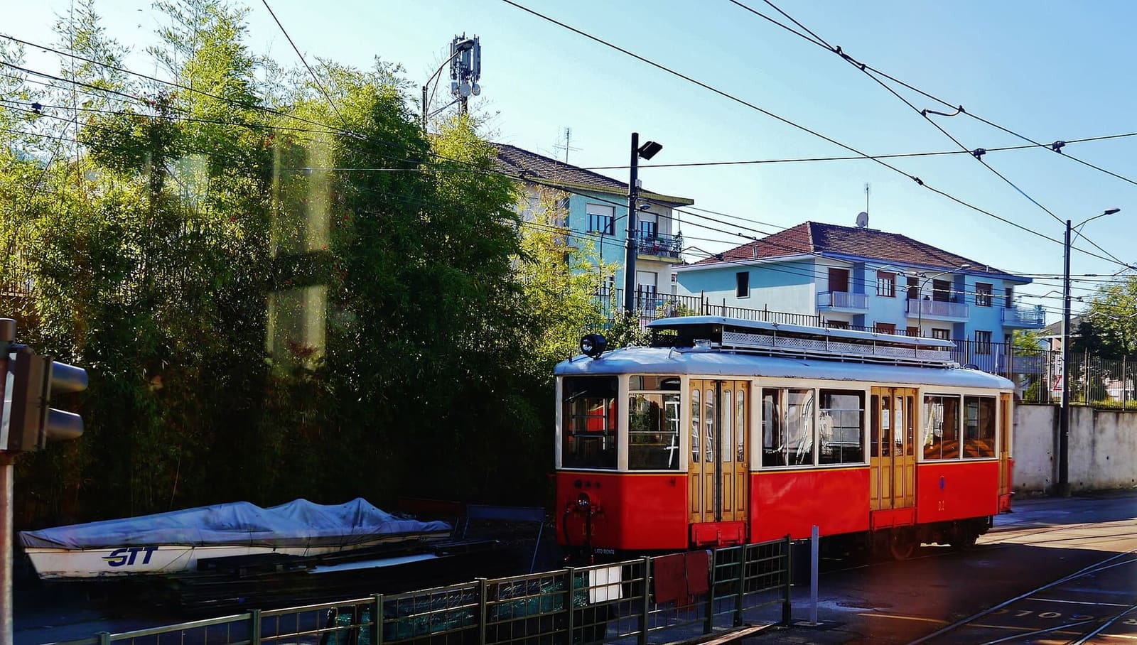 una vettura storica della tranvia a dentiera Sassi-Superga, rossa e crema, fra le case in fondo alla salita