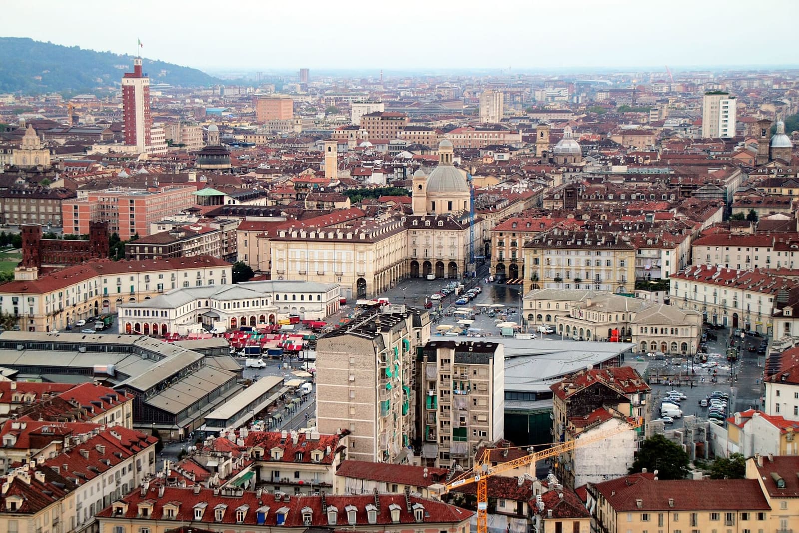 piazza della Repubblica dall'alto, con le tettoie del mercato di Porta Palazzo e la collina sullo sfondo