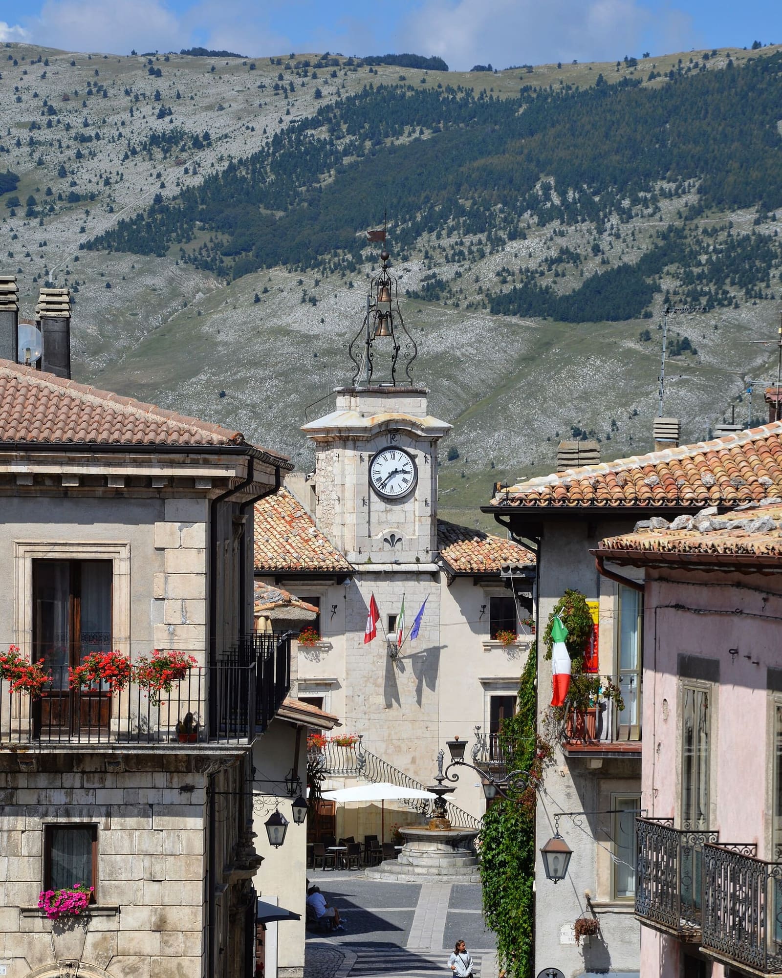 the clock tower of the town hall of Pescocostanzo, in front of the mountains