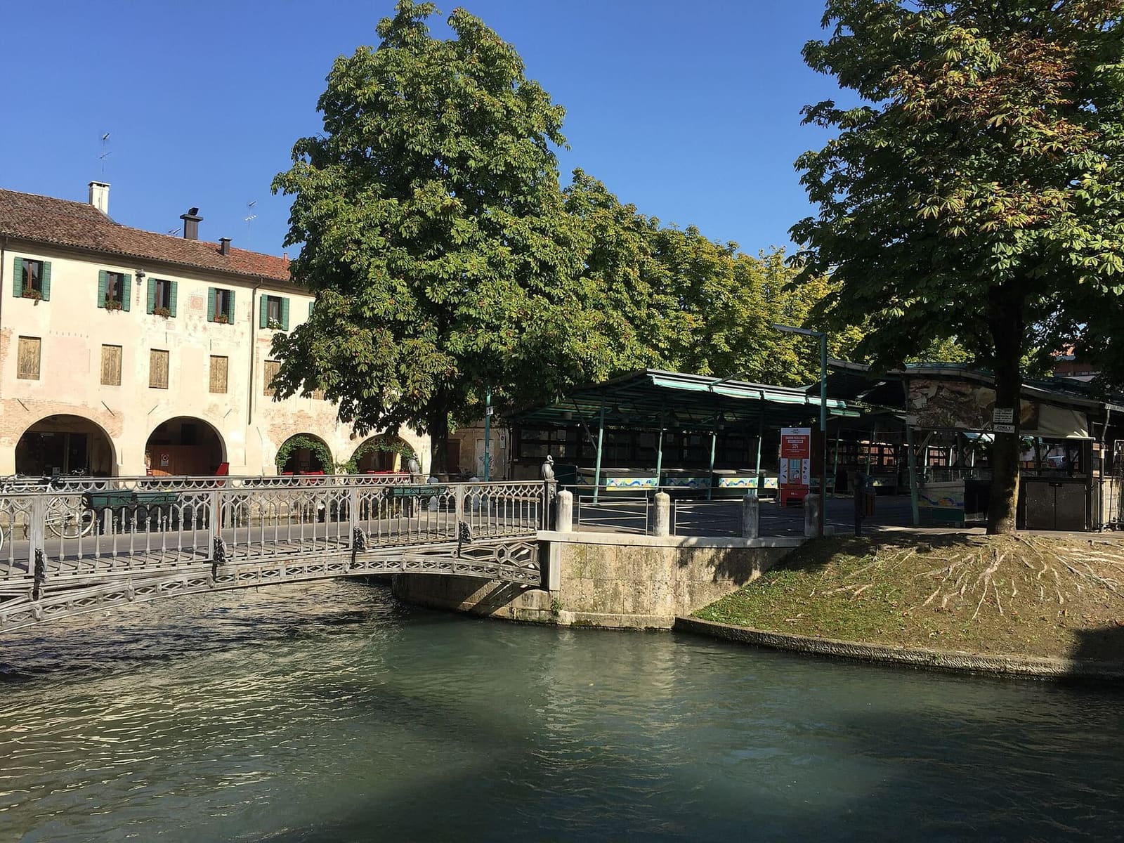 die Isola della Pescheria mit der Eisenbrücke und den Ständen des Fischmarkts unter den Kastanien