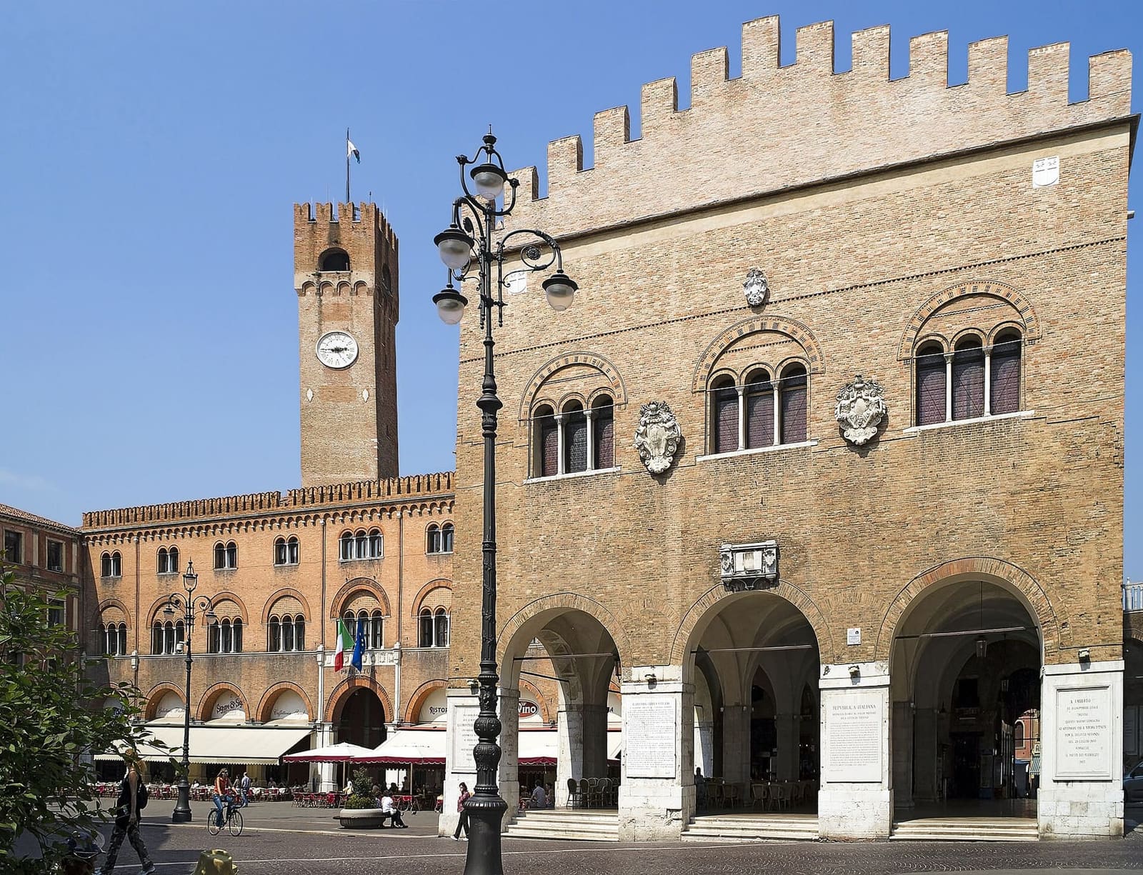 die piazza dei Signori mit dem Palazzo dei Trecento, den Laubengängen und dem Stadtturm, an einem Maimorgen