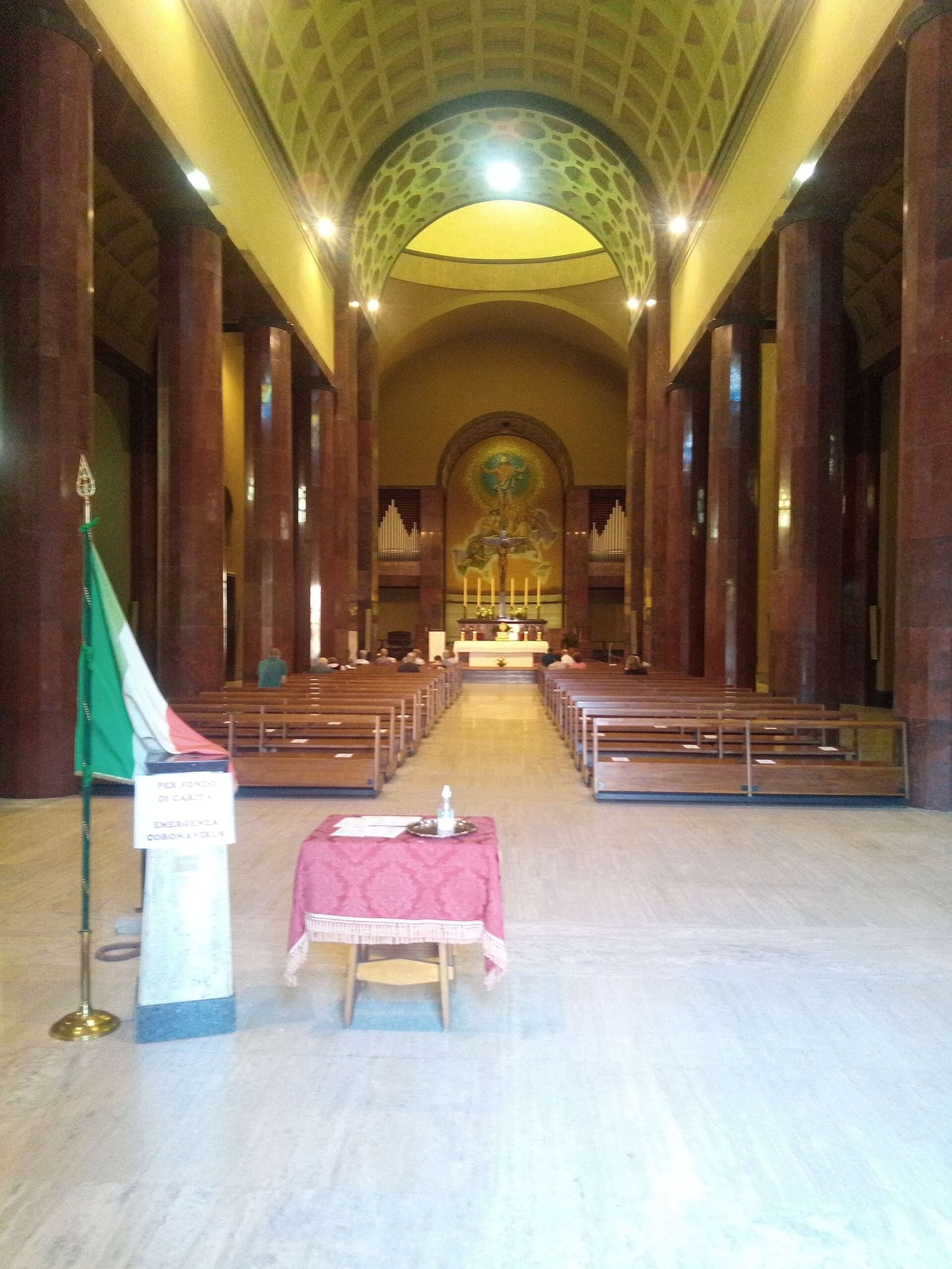 das Kirchenschiff des Tempio Ossario, mit der italienischen Fahne neben dem Eingang