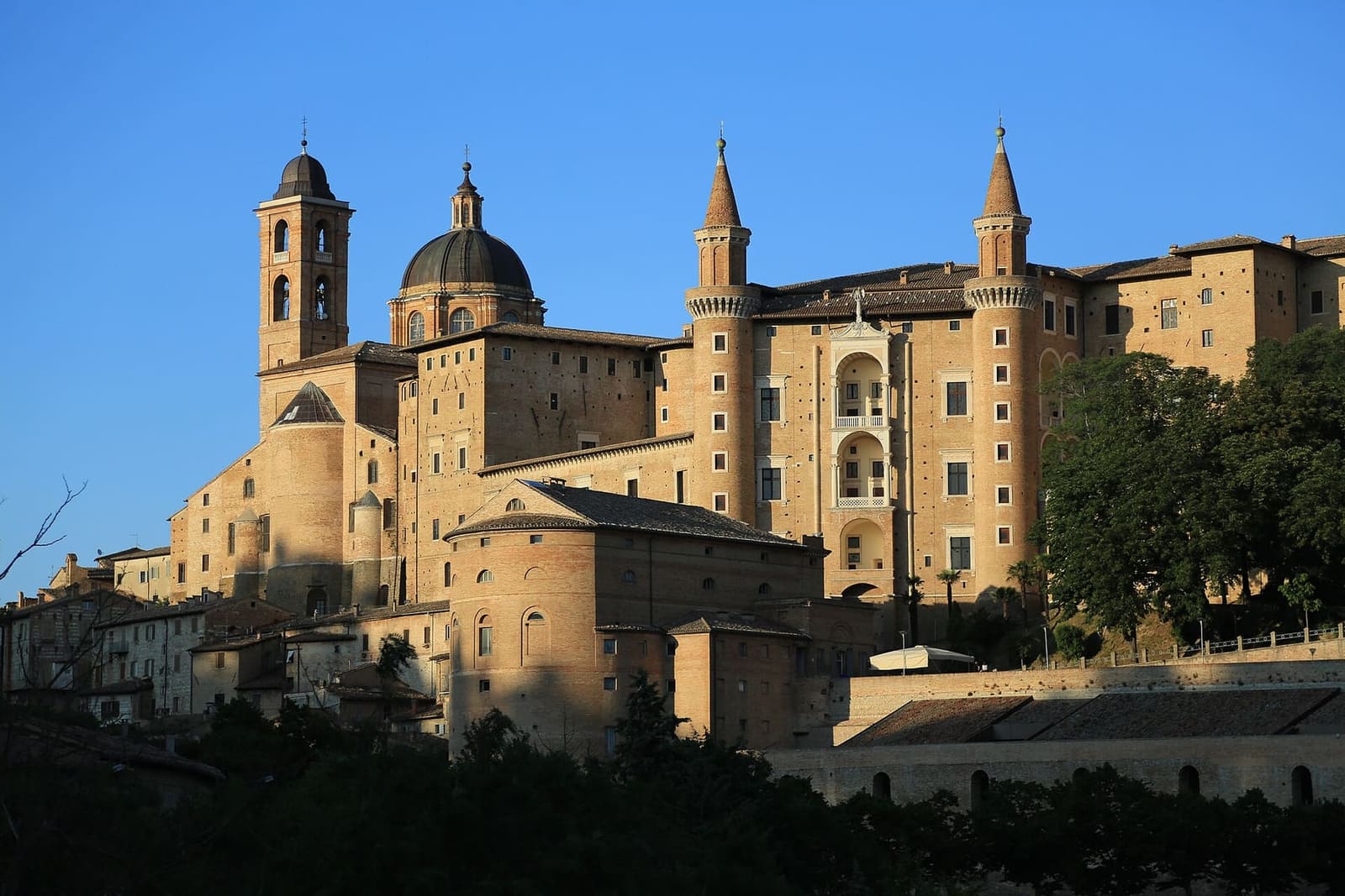 il Palazzo Ducale e il duomo nella luce della sera, con i due torricini e le logge in mezzo, la cupola e il campanile a sinistra